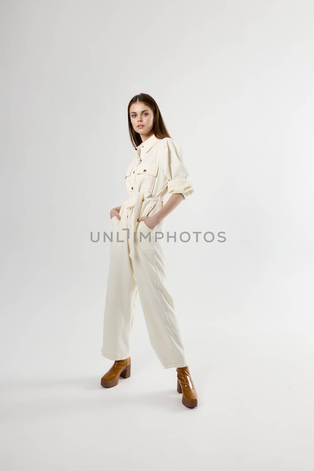 pretty woman in white jumpsuit brown shoes fashion posing. High quality photo