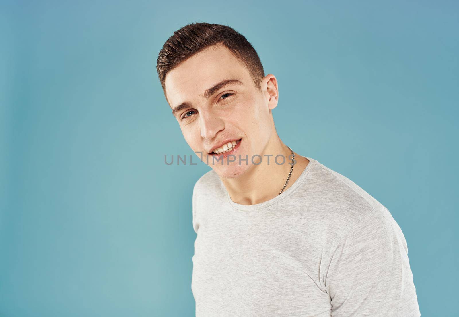 handsome man white t-shirt cropped view emotion blue background by SHOTPRIME