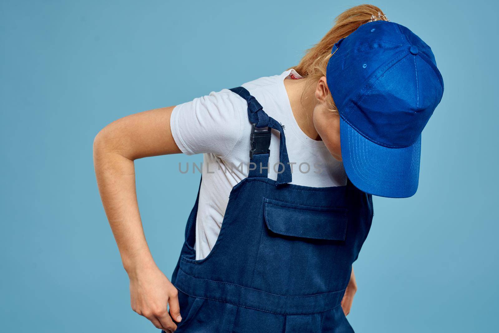 Woman in work uniform professional service blue background. High quality photo