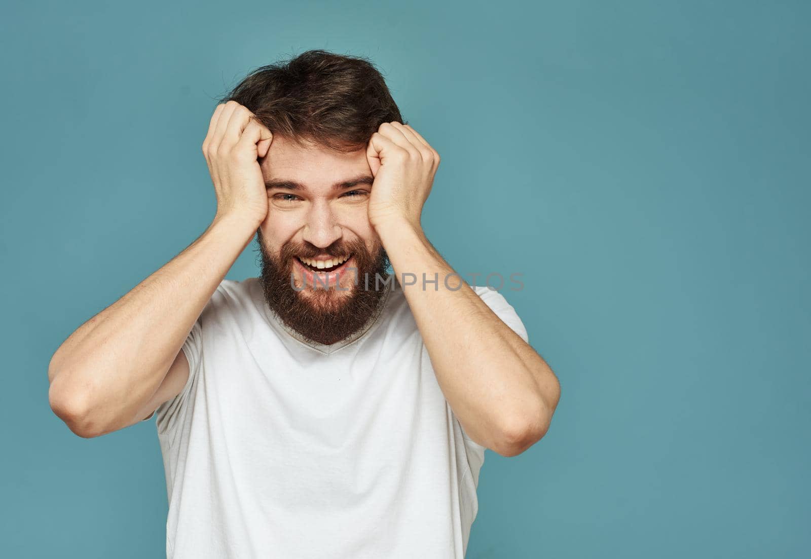 Emotional man on a blue background gestures with his hands surprise model delight. High quality photo