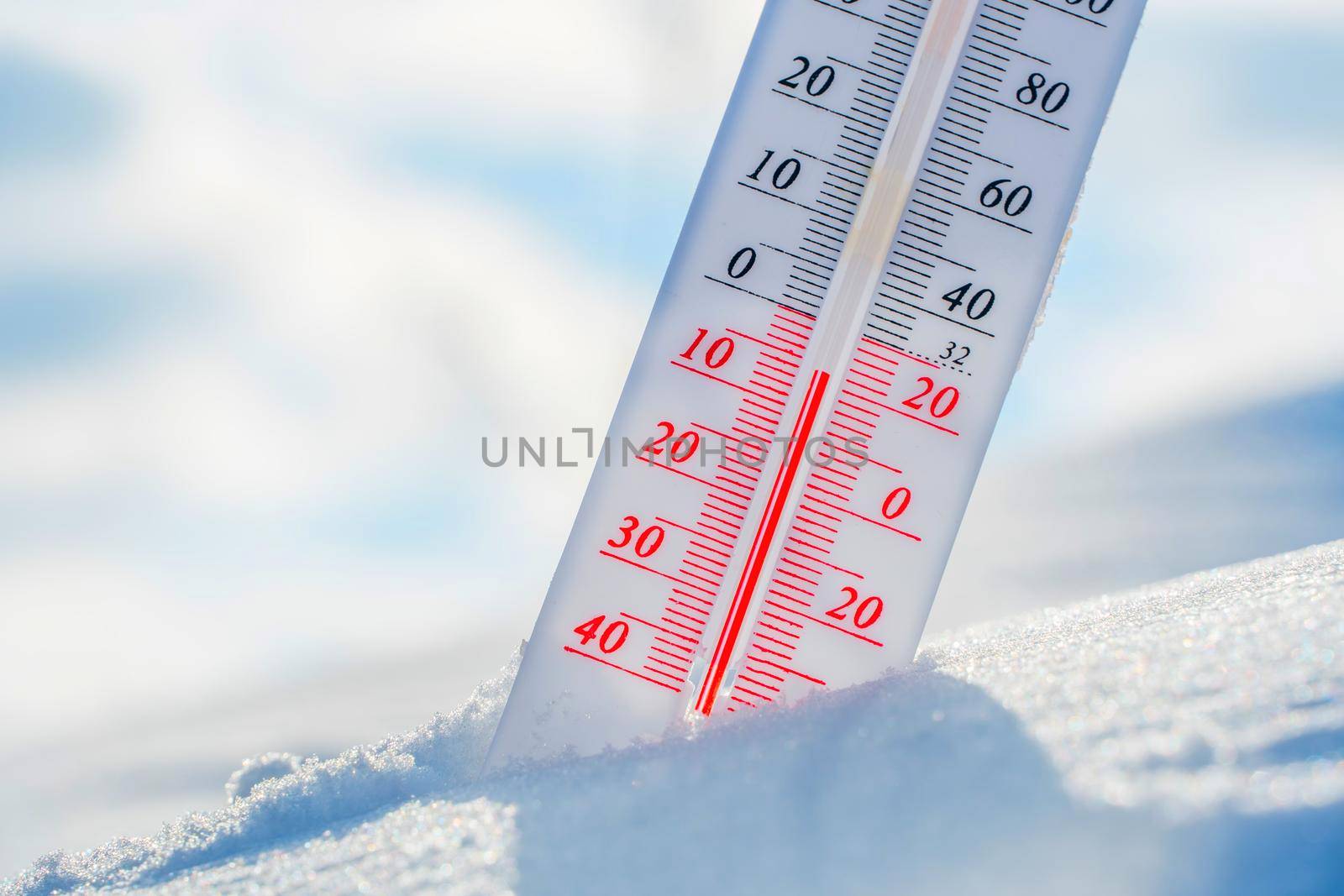 The thermometer lies on the snow in winter showing a negative temperature.Meteorological conditions in a harsh climate in winter with low air and ambient temperatures.Freeze in wintertime.Sunny winter by YevgeniySam