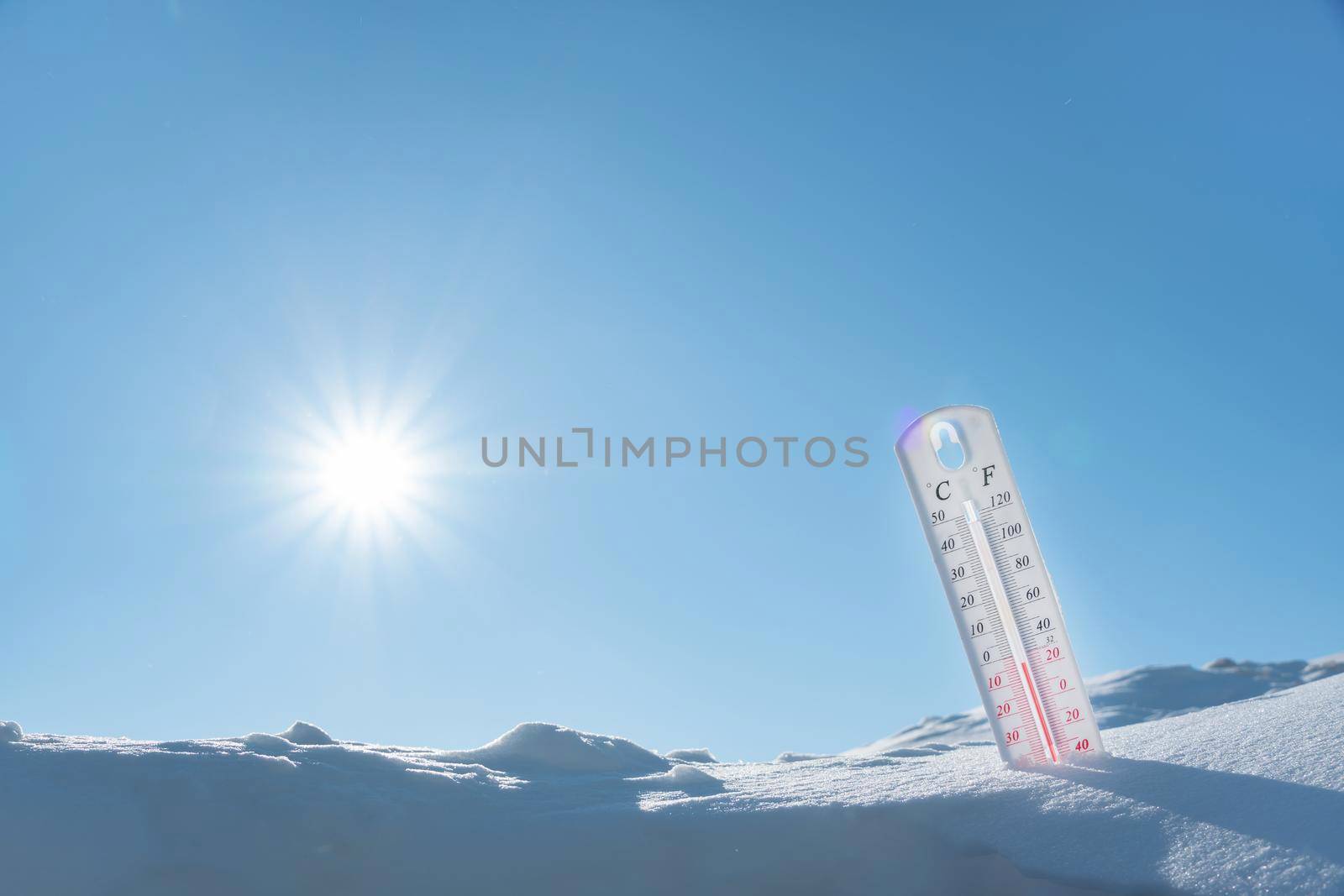 The thermometer lies on the snow in winter showing a negative temperature.Meteorological conditions in a harsh climate in winter with low air and ambient temperatures.Freeze in wintertime.Sunny winter by YevgeniySam