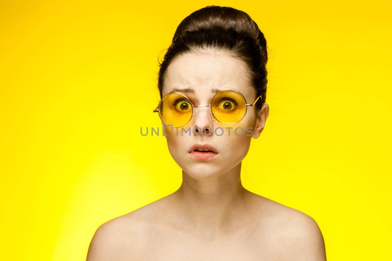 attractive woman with bare shoulders yellow glasses isolated background. High quality photo