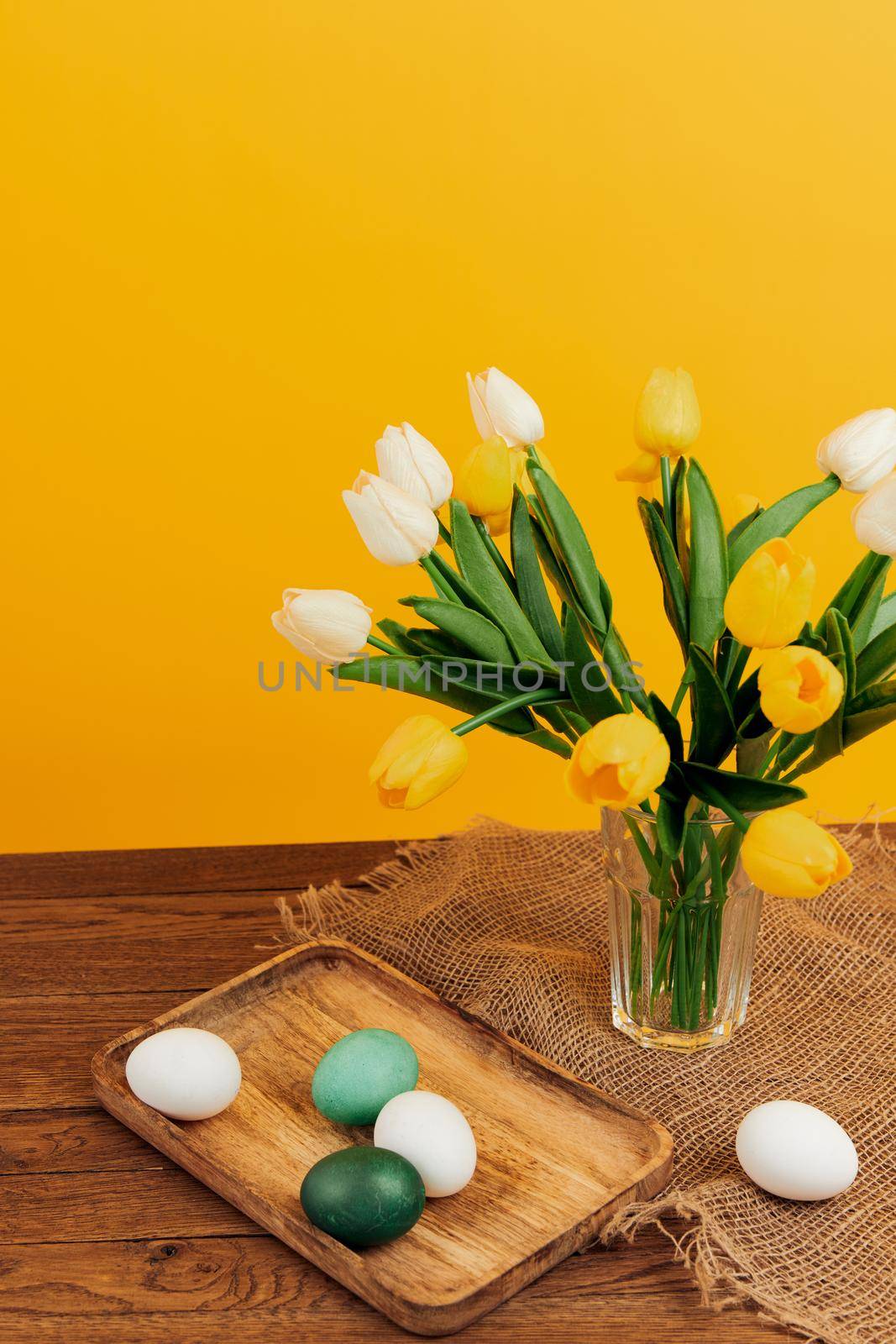 bouquet of flowers in a vase easter eggs decoration holiday yellow background by SHOTPRIME