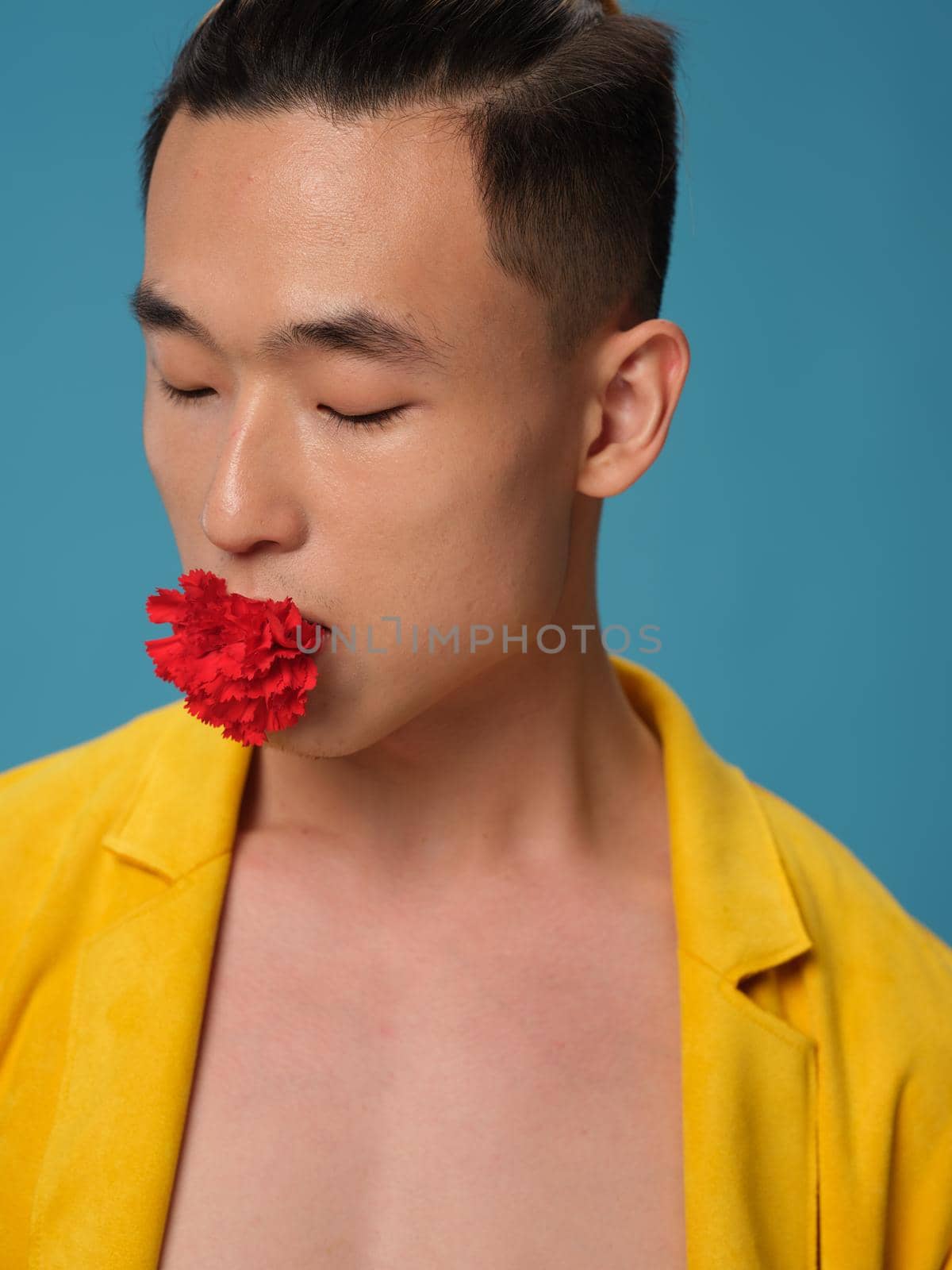 Korean appearance guy with a flower in his mouth on a blue background and a yellow jacket portrait by SHOTPRIME
