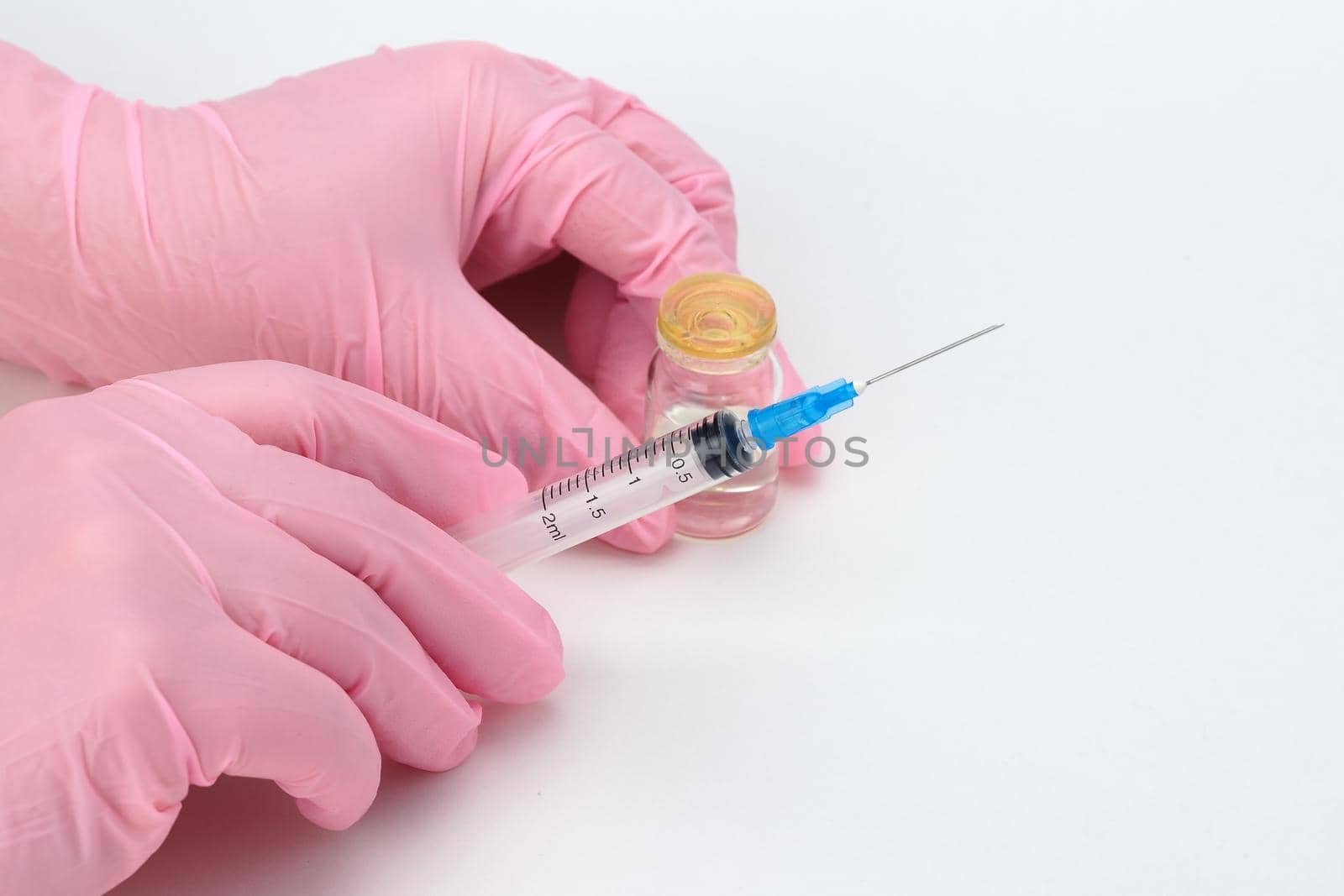 A doctor in medical gloves holds a syringe and a vial with a vaccine or drug in his hands by Olga26