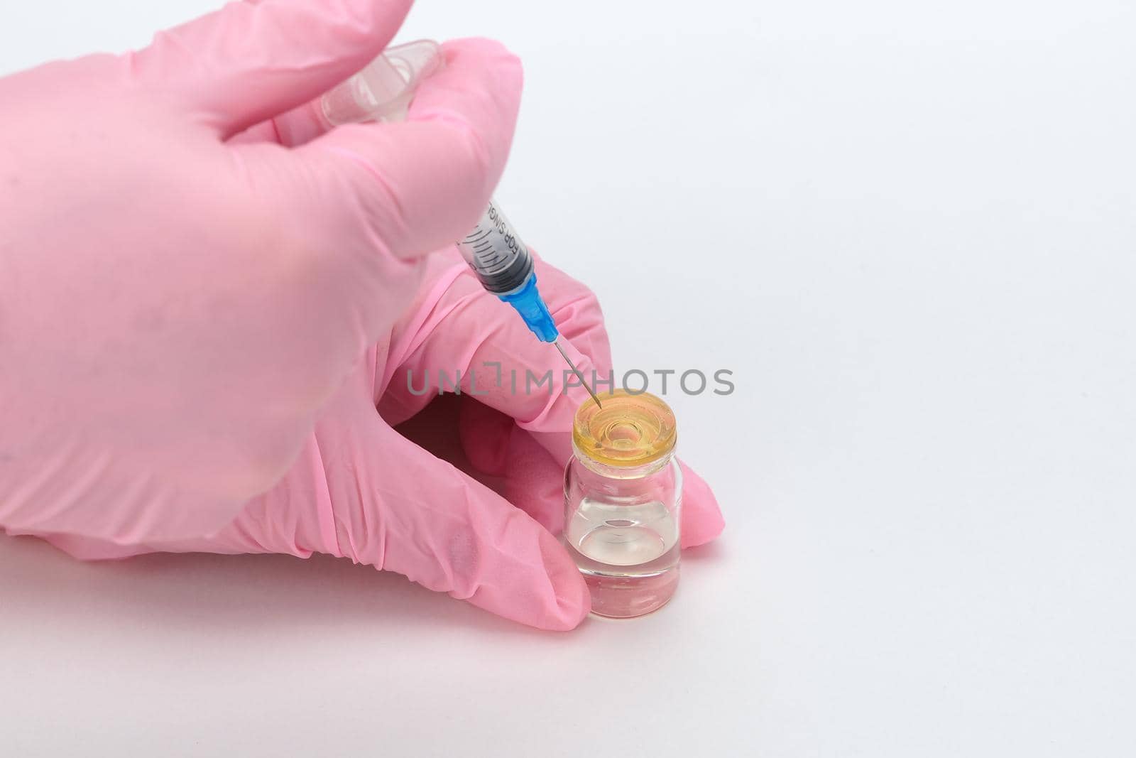 Science and medicine. Vaccination of the population. Hands of a medical professional picking up a drug or vaccine in a sterile syringe. High quality photo