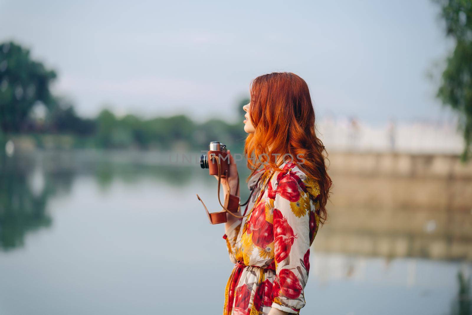 red-haired woman outdoors binoculars in hands leisure travel walk. High quality photo