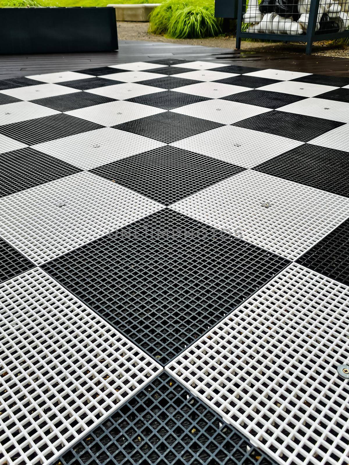 Black and white plastic chessboard at business square by Wierzchu