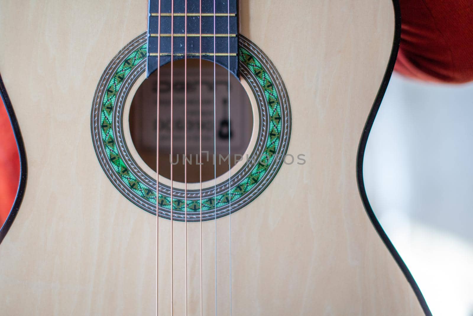 Close-up of a guitar player or a person learning to play an acoustic guitar. Home learning to play a musical instrument