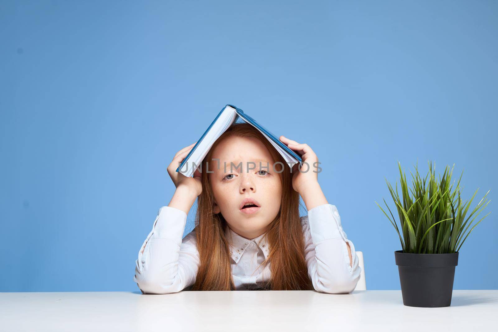schoolgirl with a book on her head learning lessons lifestyle. High quality photo