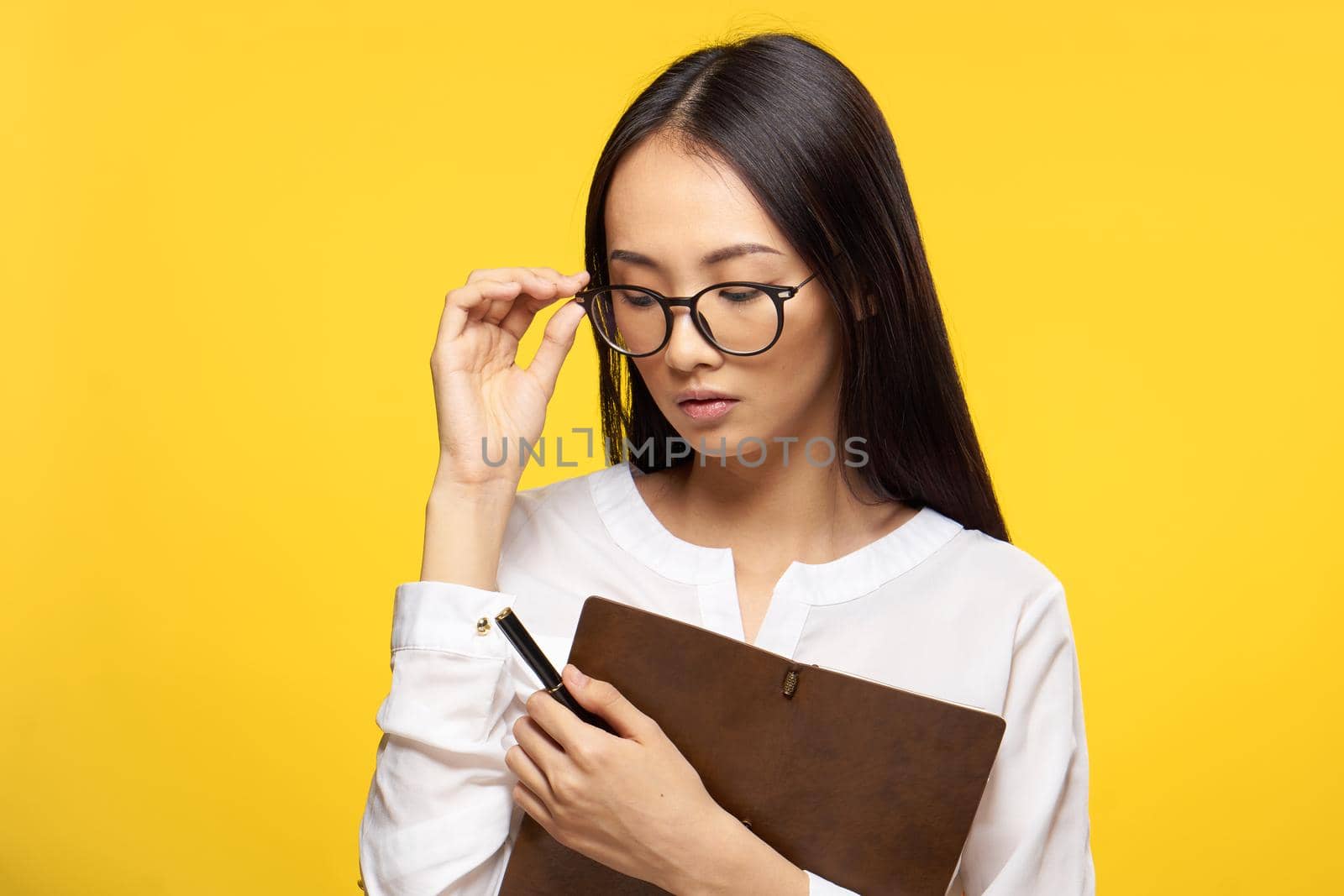 woman holding notepad secretary office yellow background. High quality photo