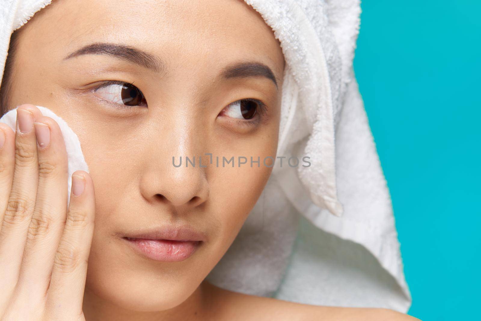 woman asian appearance clean skin close-up spa treatment blue background. High quality photo