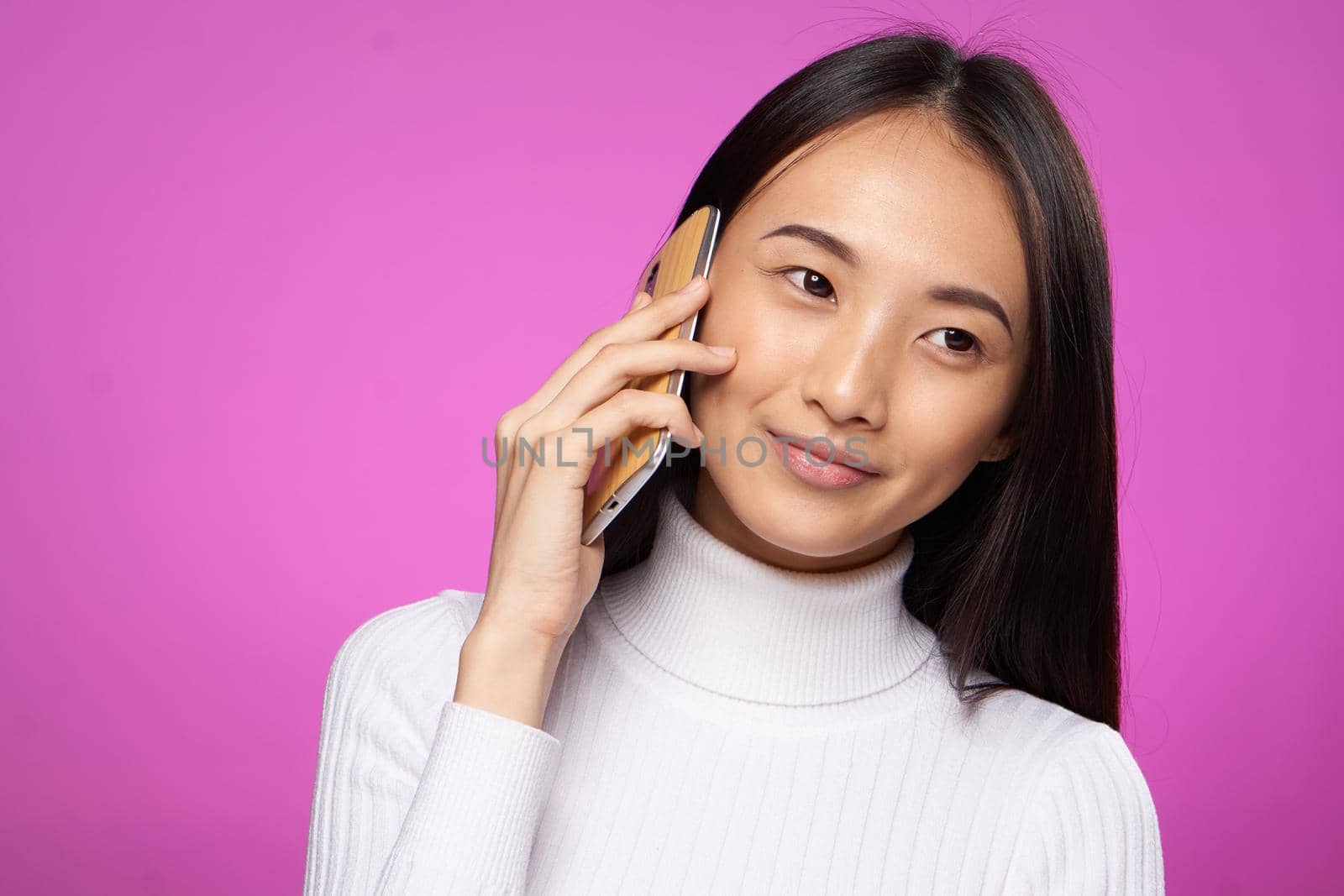 woman asian appearance talking on the phone well lifestyle technology pink background studio. High quality photo