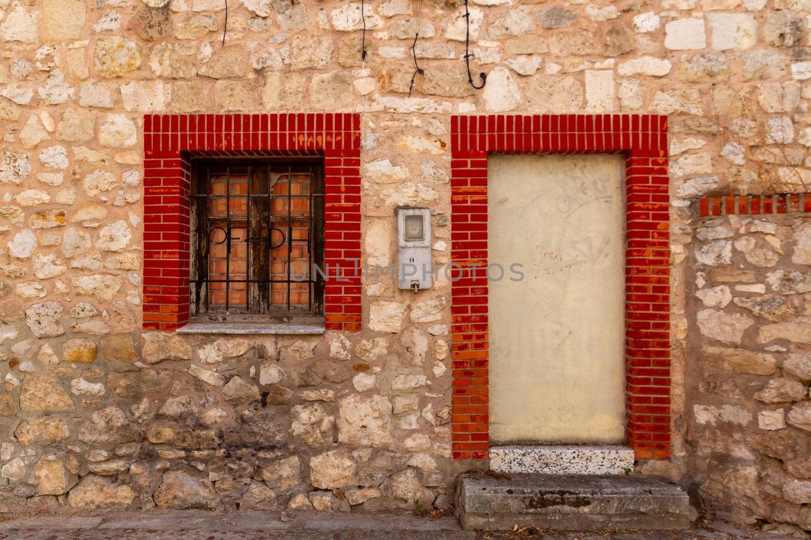 Detail of an old stone wall with a cancelled door and window