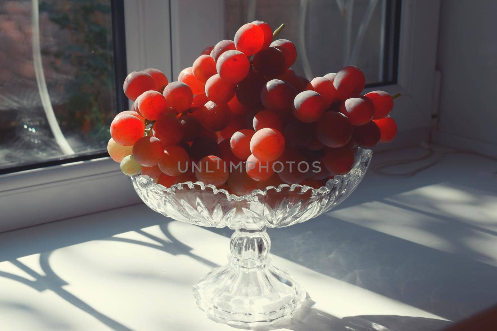 Grape in crystal vase dessert fruit on white background by IaroslavBrylov