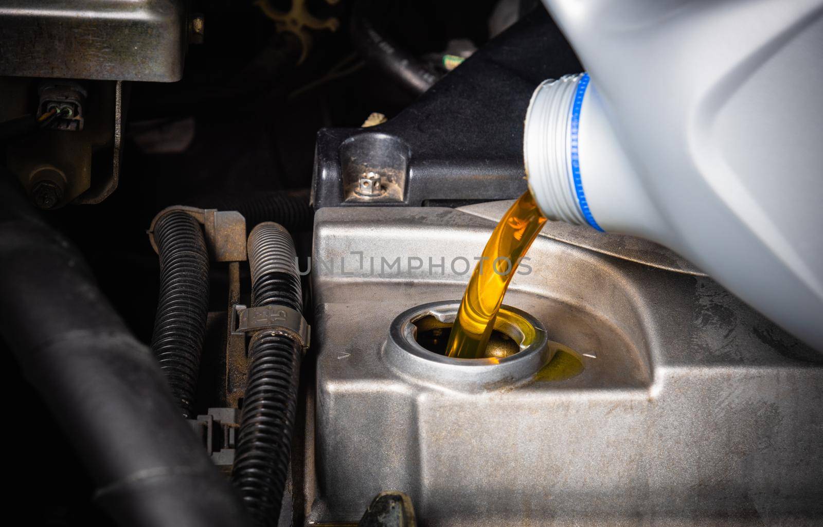 Mechanic in service to repair the car, change lubricant oil by Sorapop