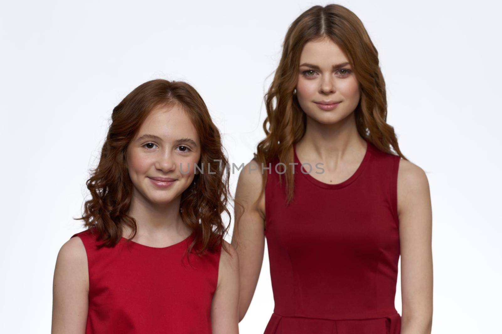 Mom and daughter stand side by side and fun family joy light background. High quality photo