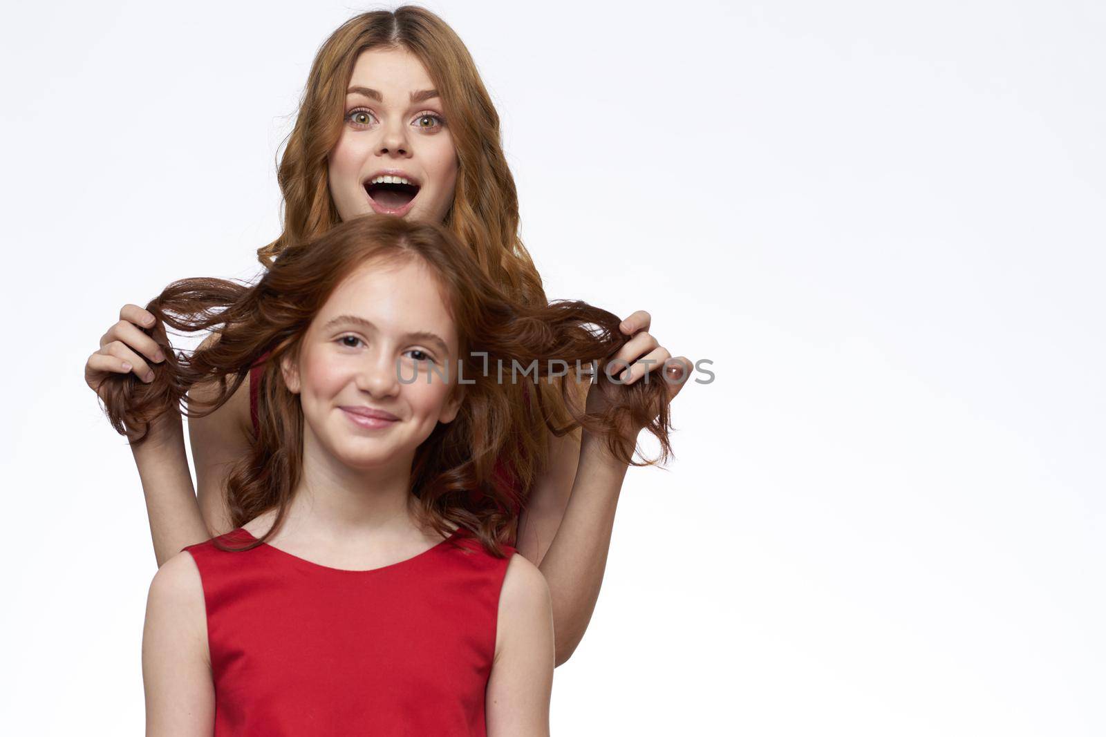 Mom and daughter stand side by side and fun family joy light background. High quality photo
