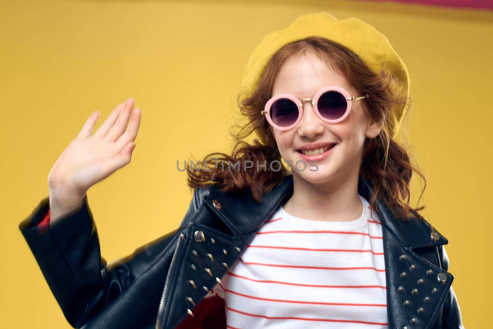 Girl in a yellow hat dark glasses fashionable clothes studio lifestyle childhood. High quality photo
