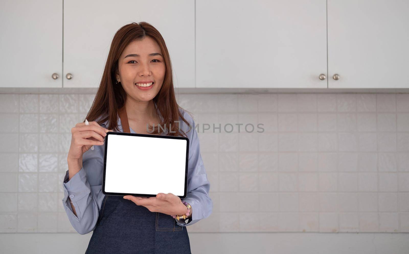 Mockup image of a woman entrepreneur holding black tablet with white blank screen