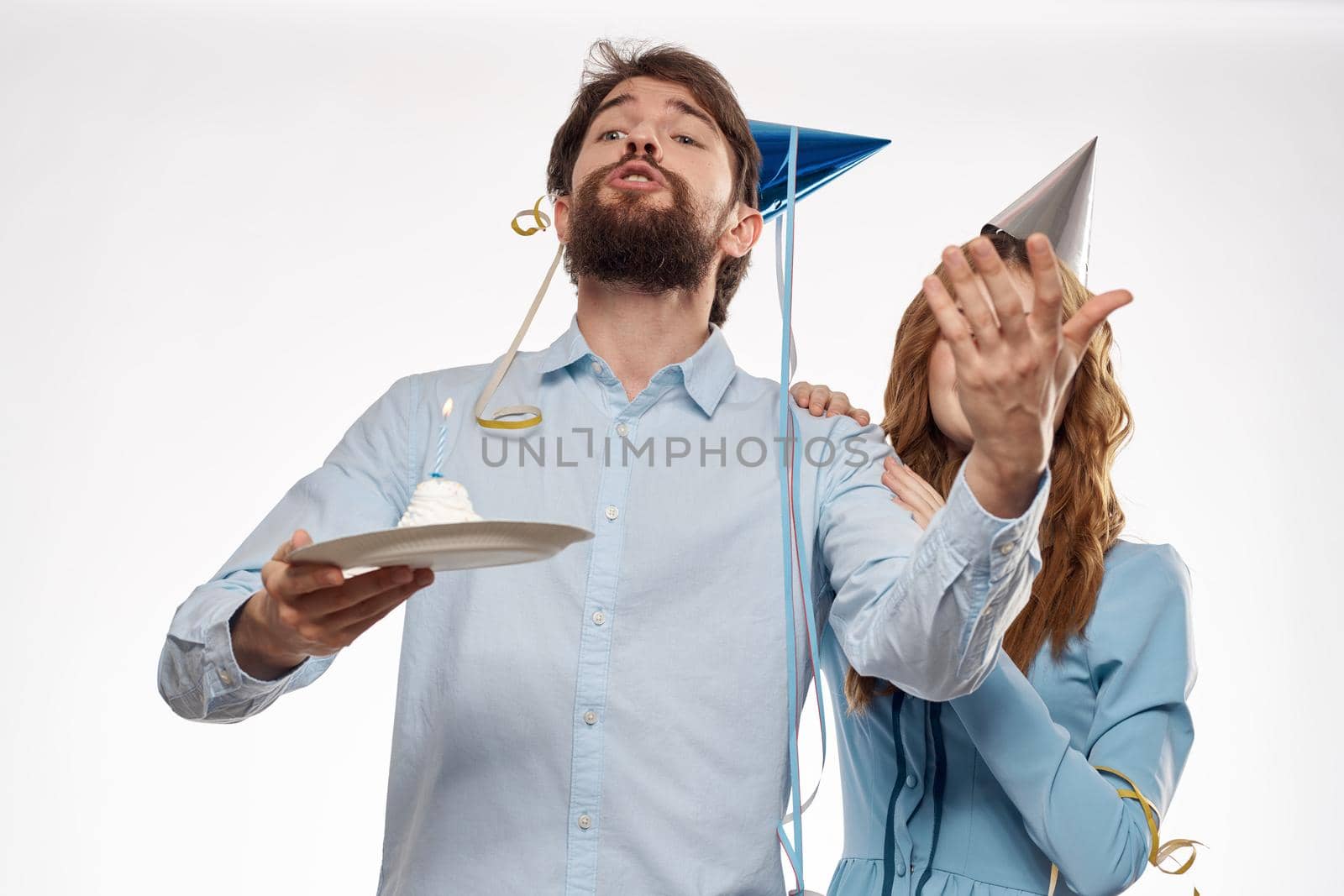 Joyful man and cheerful Woman holiday cake Birthday cap party corporate party young people by SHOTPRIME