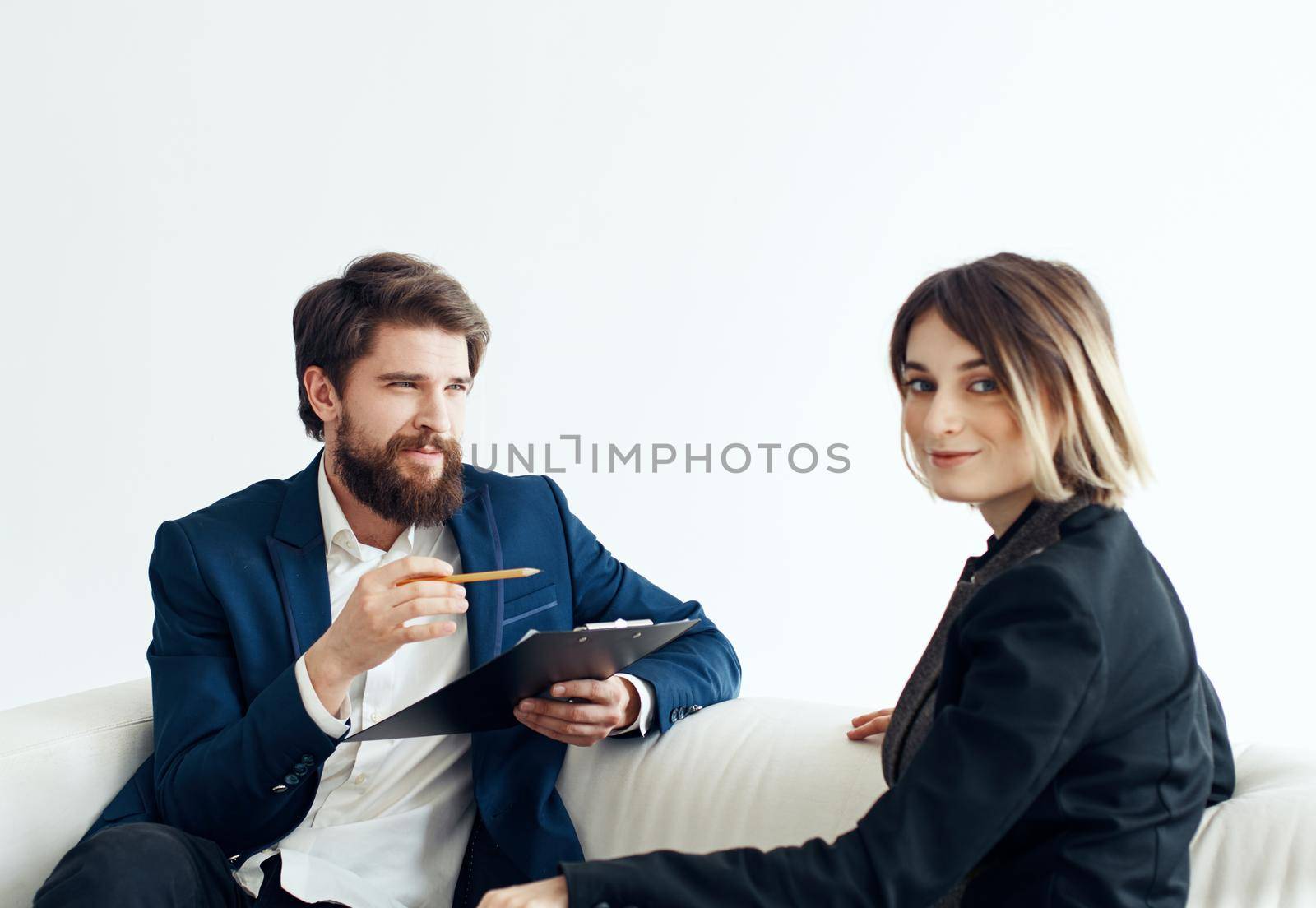 Business man and woman employees communicating on the couch indoors. High quality photo