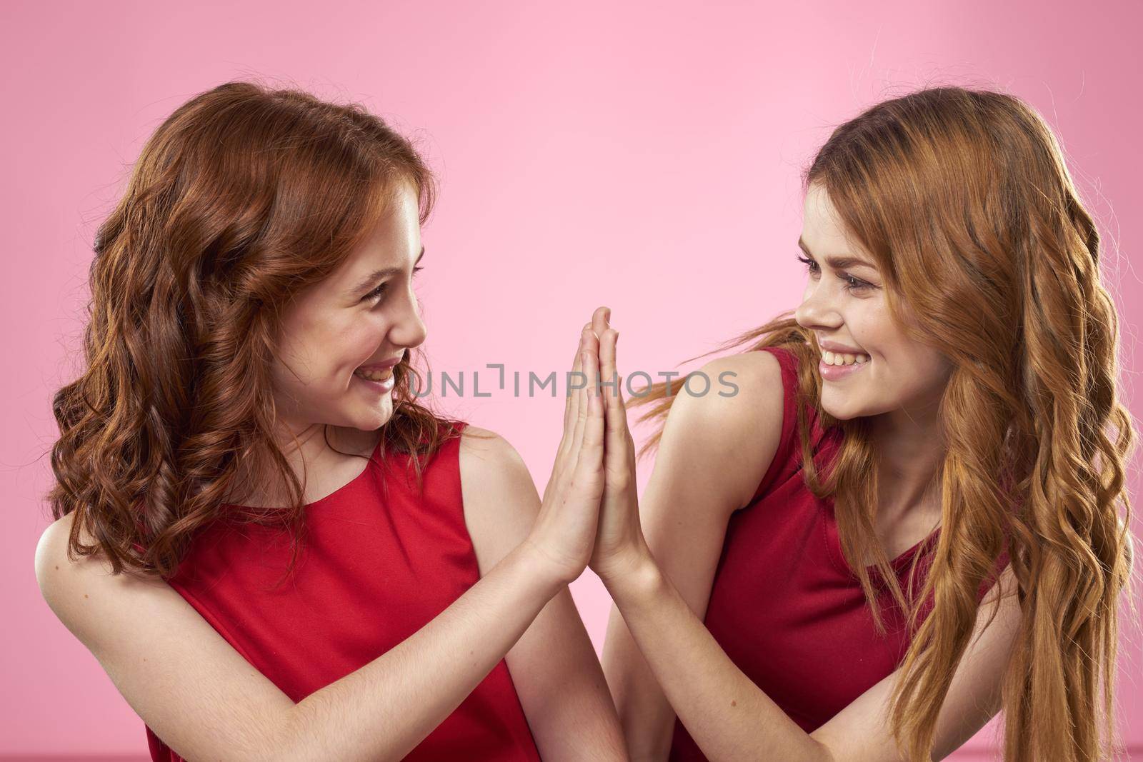 Mom and daughter fun communication family joy pink background cropped view. High quality photo