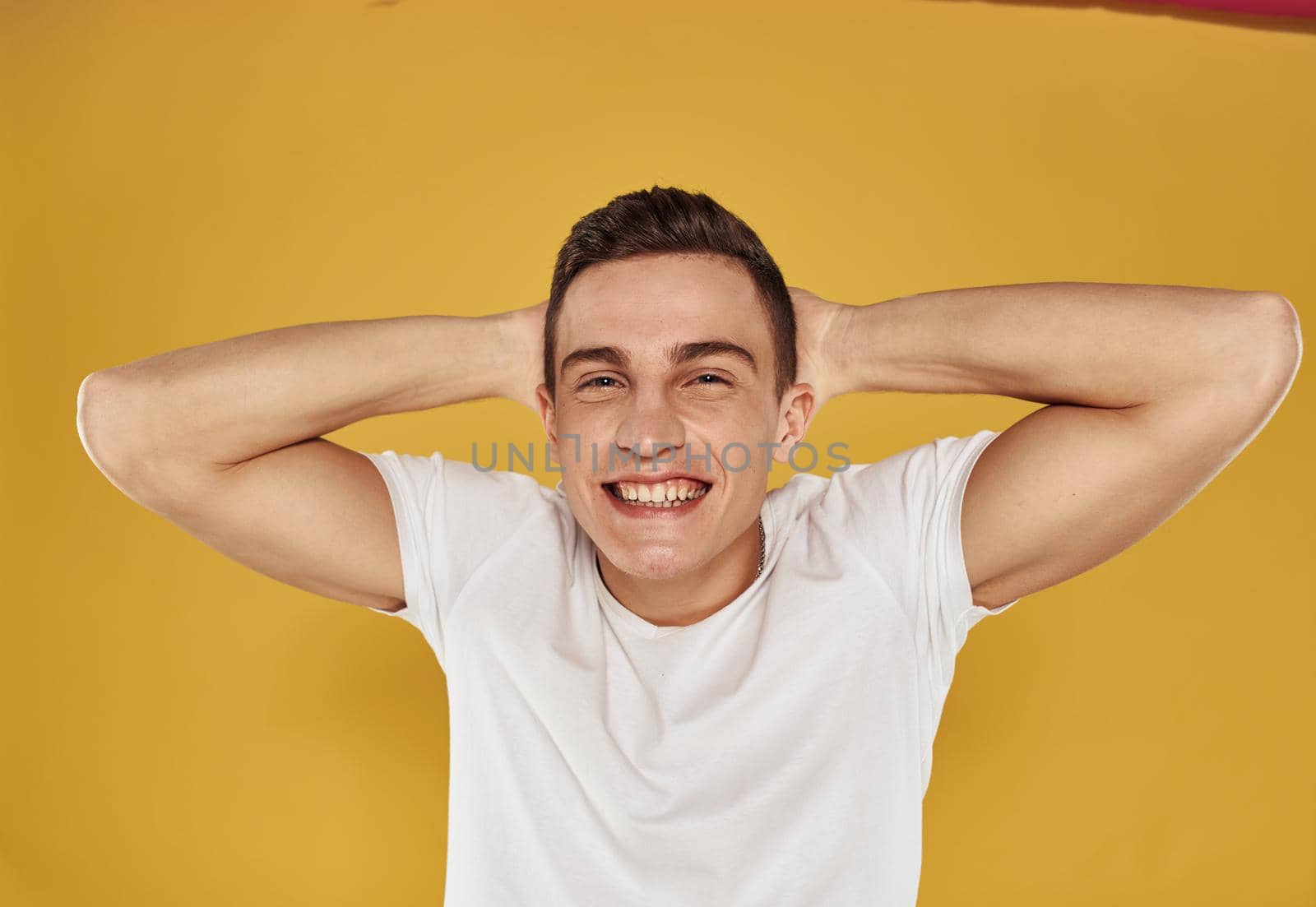 Happy guy gestures with his hands fun emotions model yellow background by SHOTPRIME