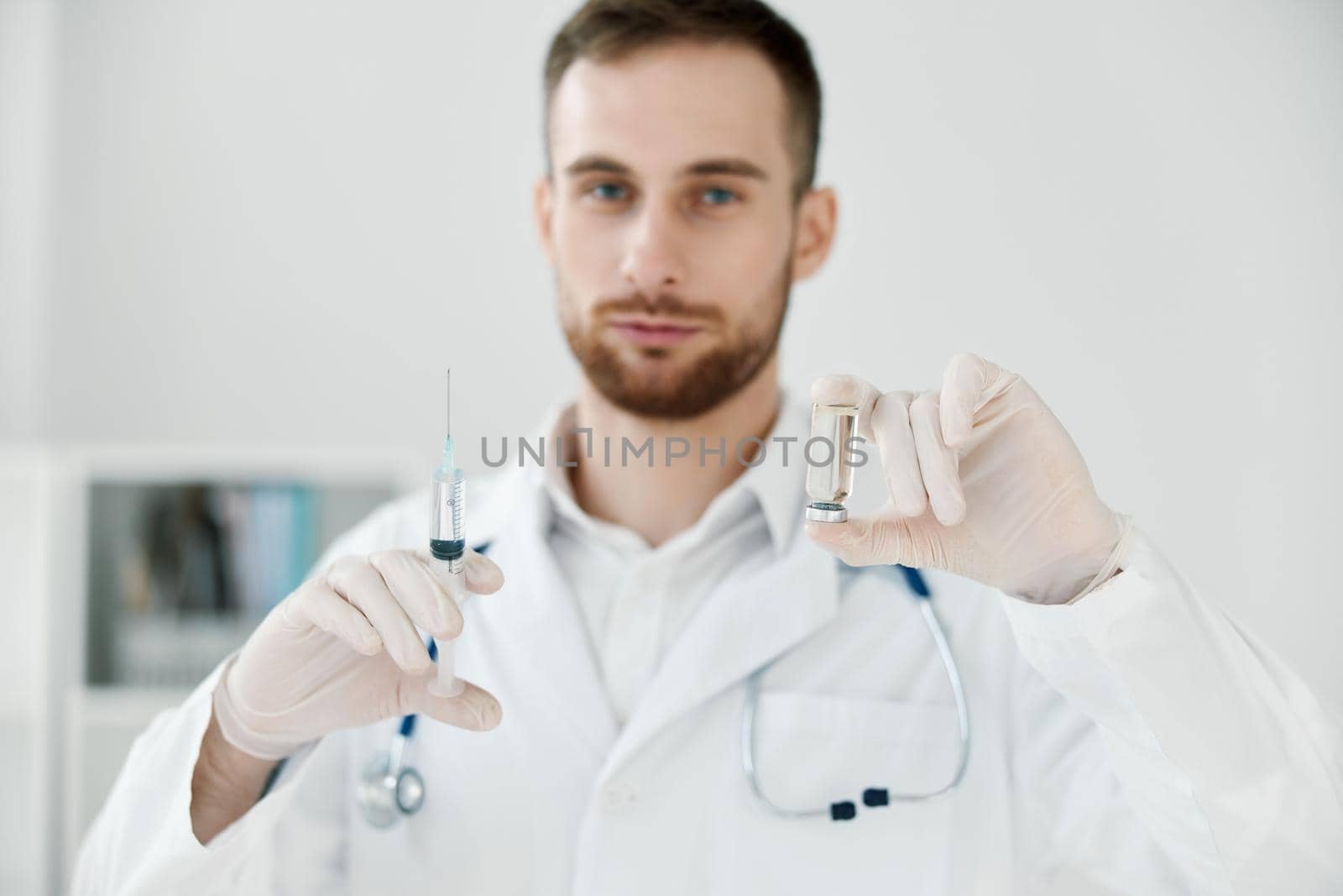 male doctor in a medical gown holds a syringe in his hand vaccine health care laboratory chemical liquid. High quality photo