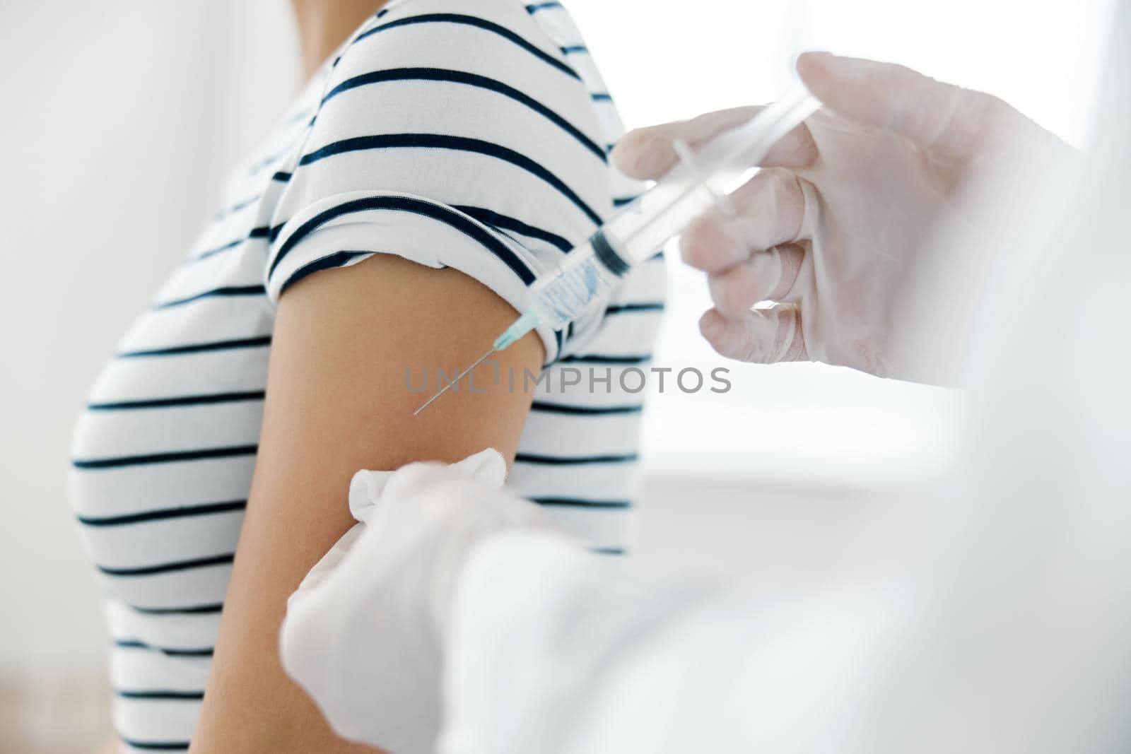 Injection of vaccine into shoulder in hospital close-up by SHOTPRIME