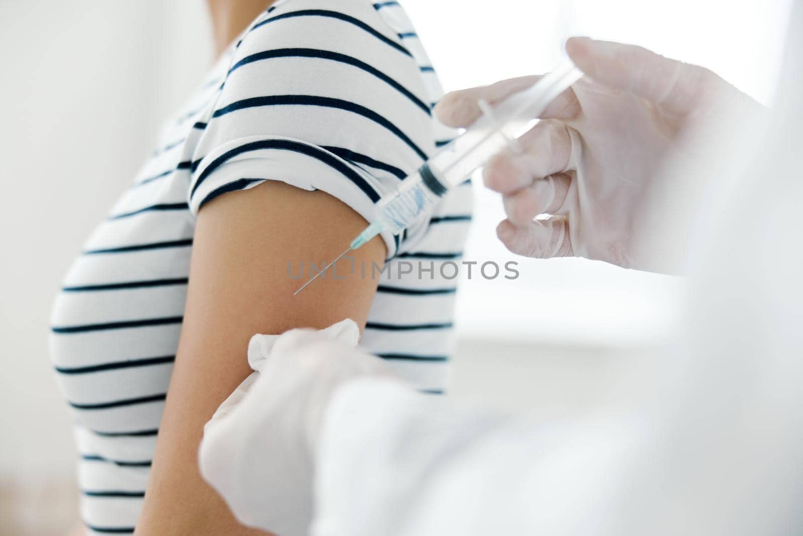 Injection of vaccine into shoulder in hospital close-up. High quality photo