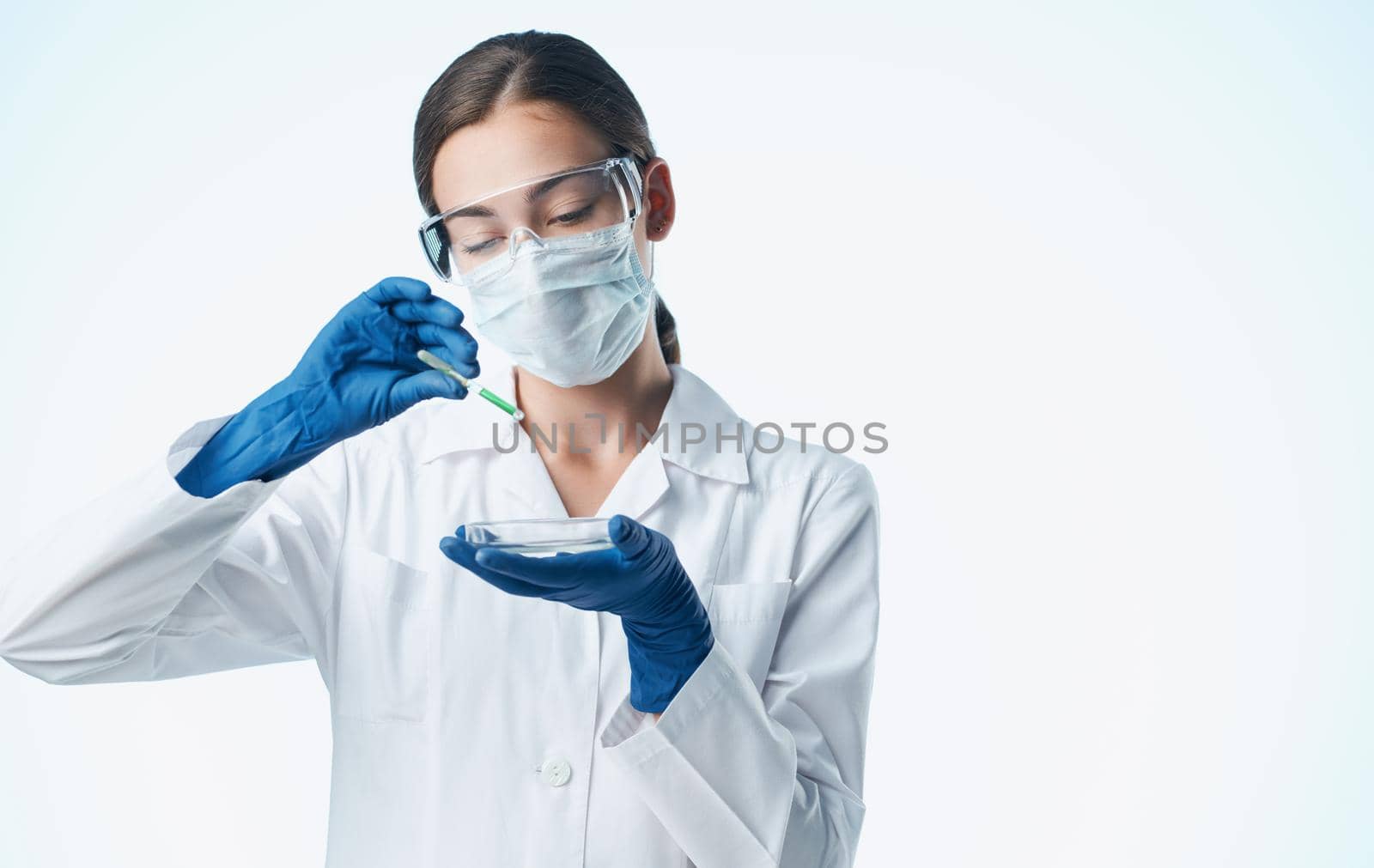 female laboratory assistant in a medical mask with a chemical element in a flask vaccination by SHOTPRIME
