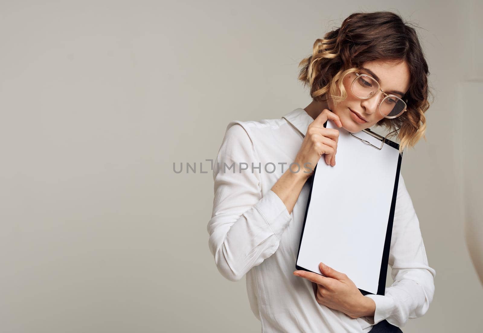 Woman with a white sheet of paper in a folder with short hair Copy Space. High quality photo