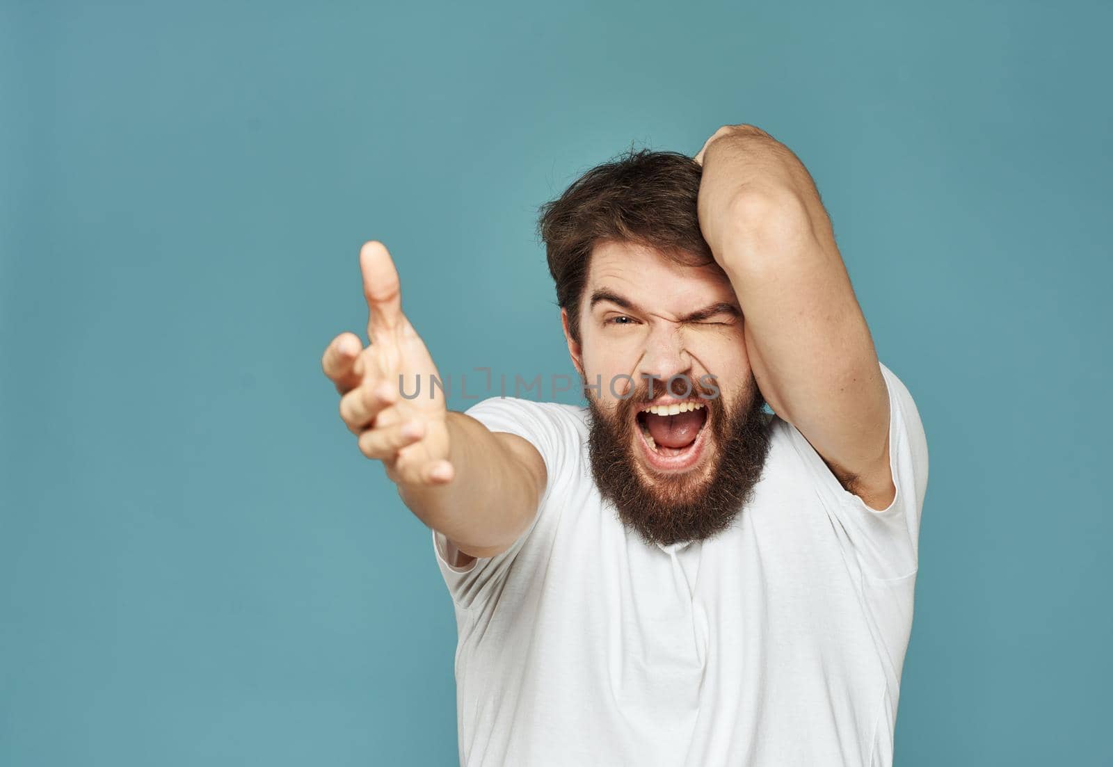 Close-up of a man gesturing with his hands on a blue background cropped view. High quality photo