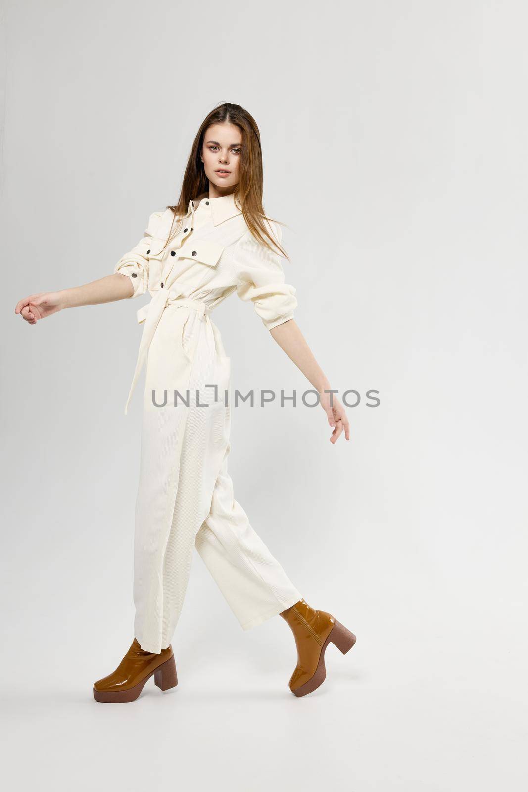 fashionable woman in white jumpsuit on a light background stylish clothes emotions model by SHOTPRIME