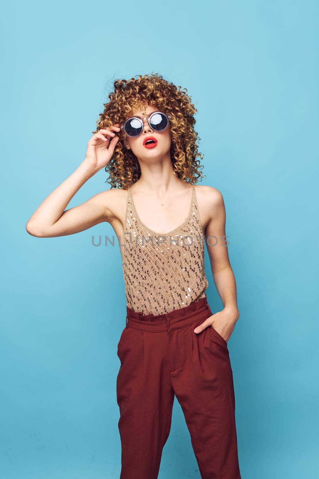 woman curly hair sunglasses attractive look red lips red pants isolated background