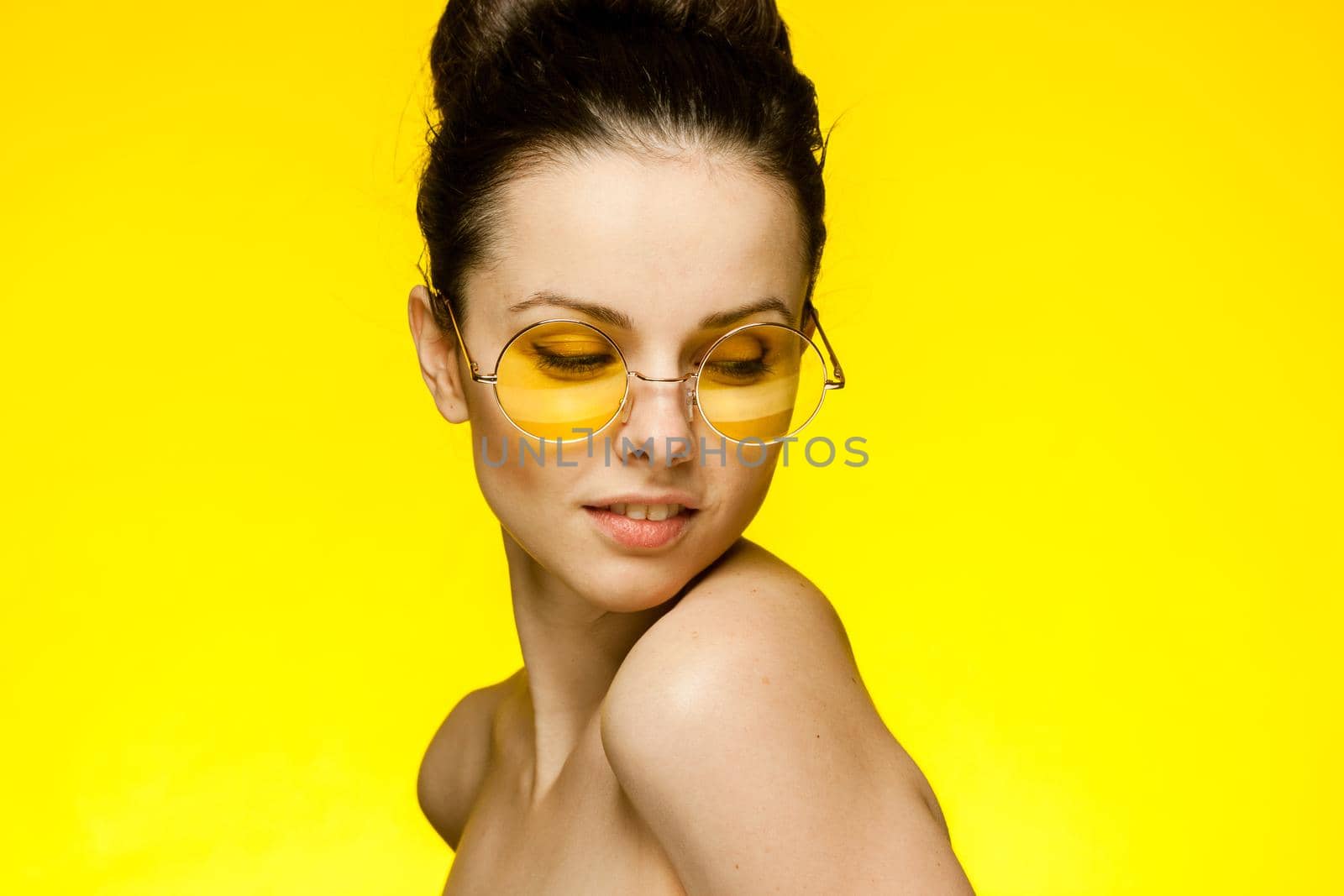 brunette with bare shoulders attractive glamor look yellow background. High quality photo