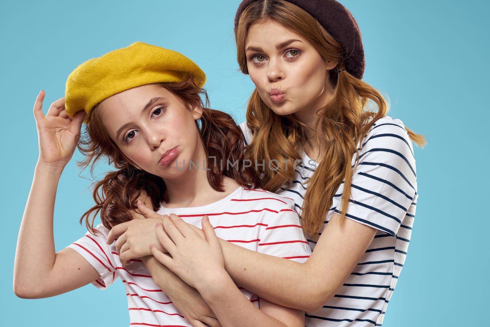 Cheerful mom and little daughter hat fashionable clothes woman joy blue background. High quality photo