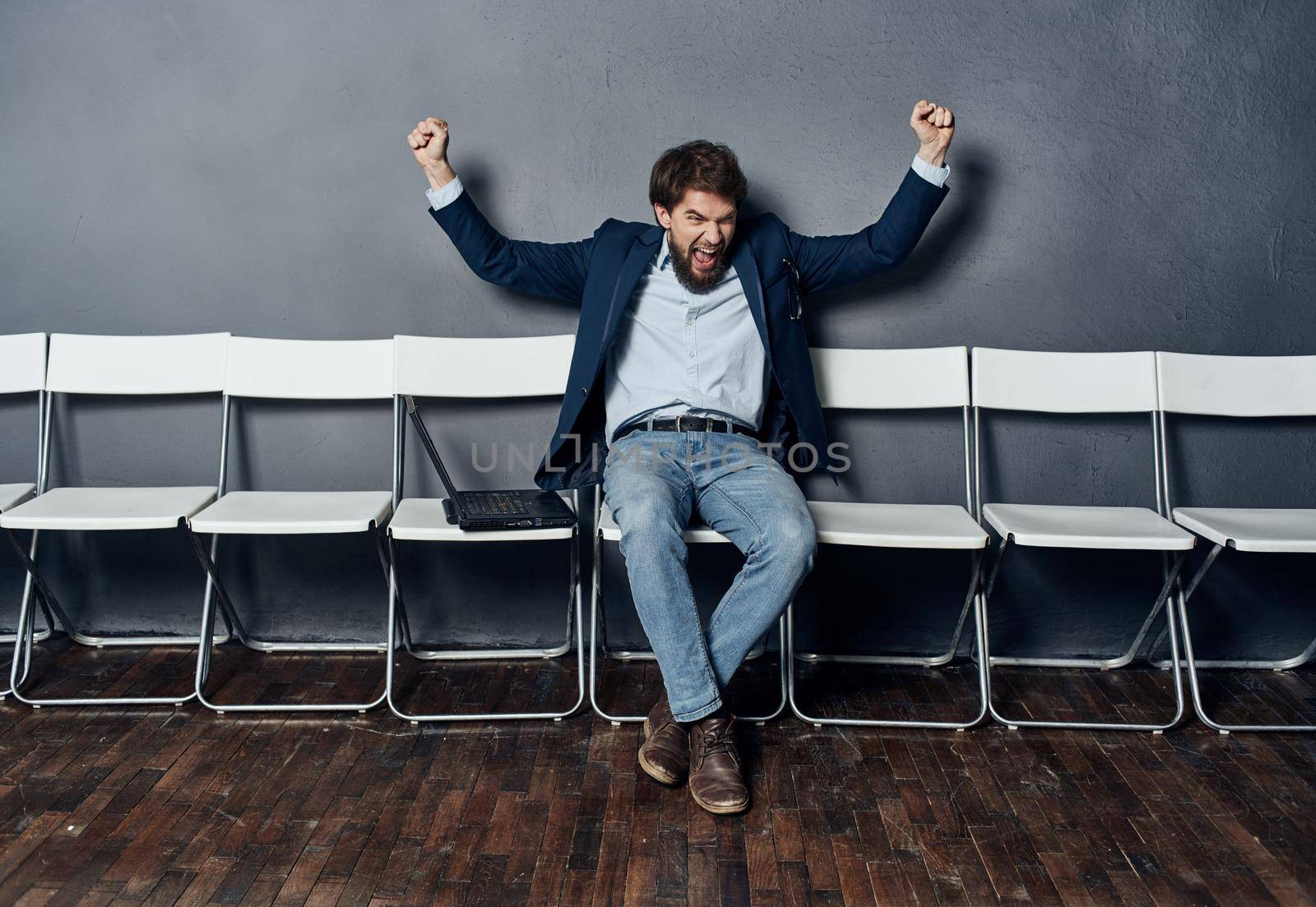 Business man in a suit sitting on a chair waiting laptop work office job interview. High quality photo