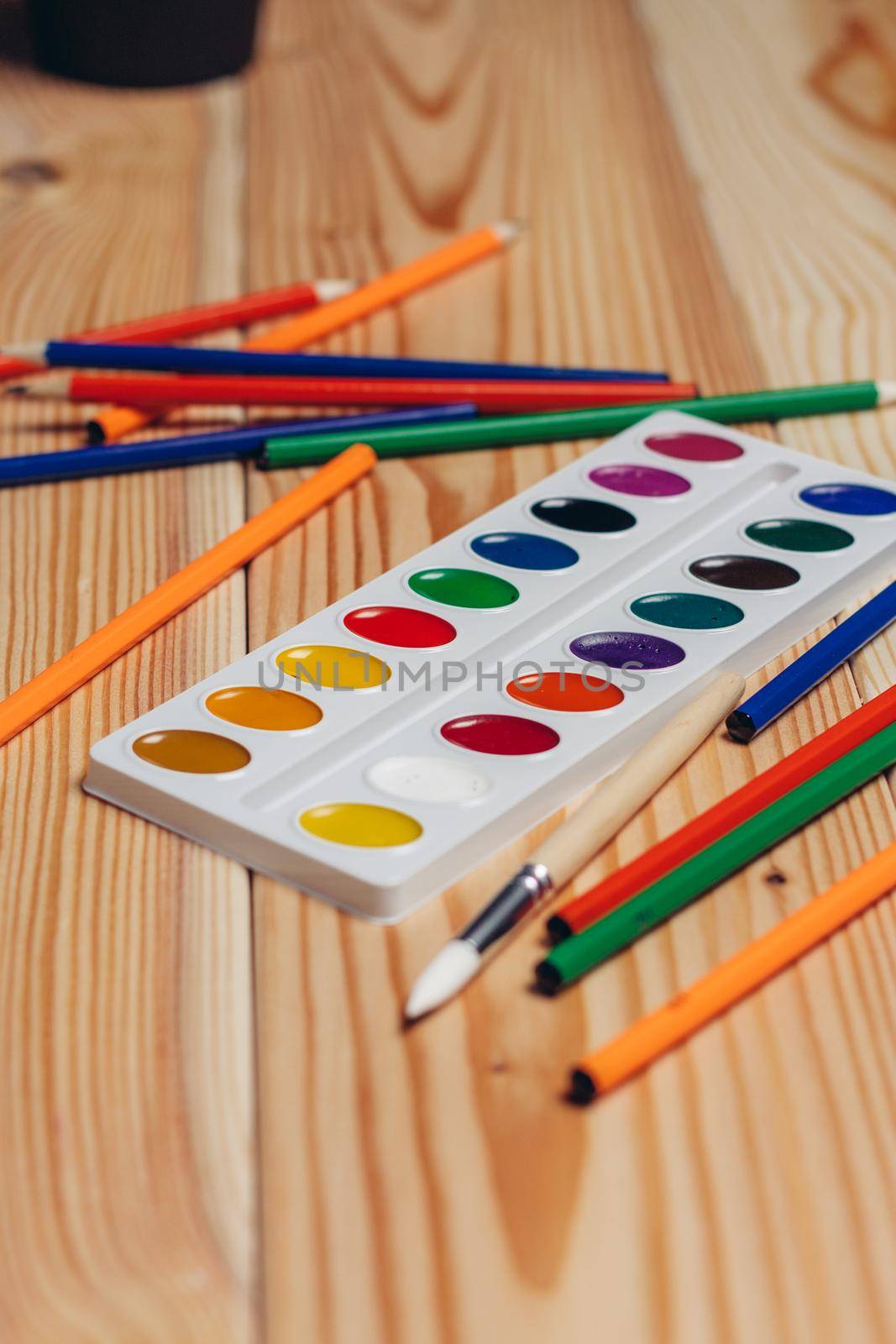 stationery colored pencils paint wooden table. High quality photo