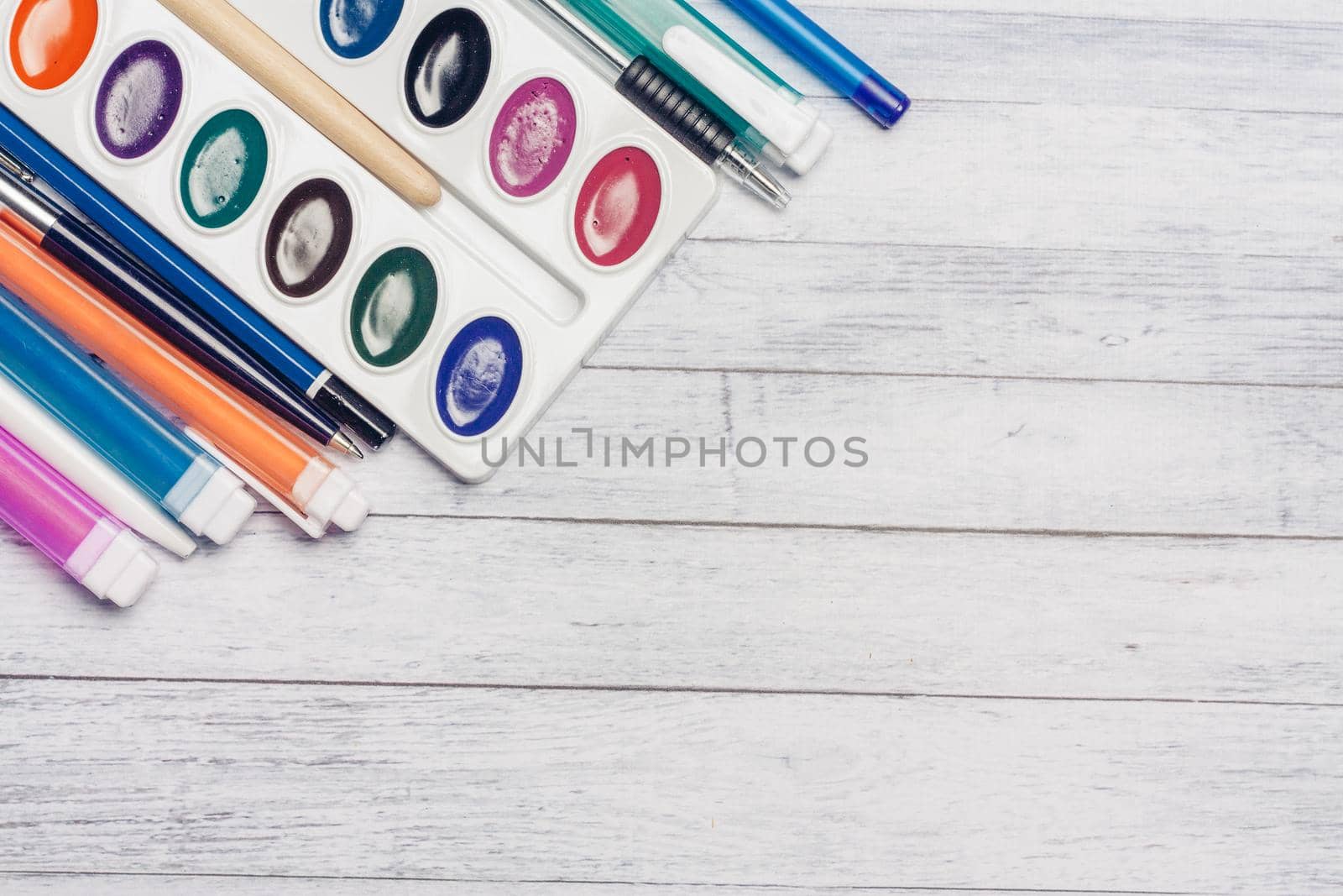 watercolor paint markers and pencils on a wooden table top view Copy Space. High quality photo