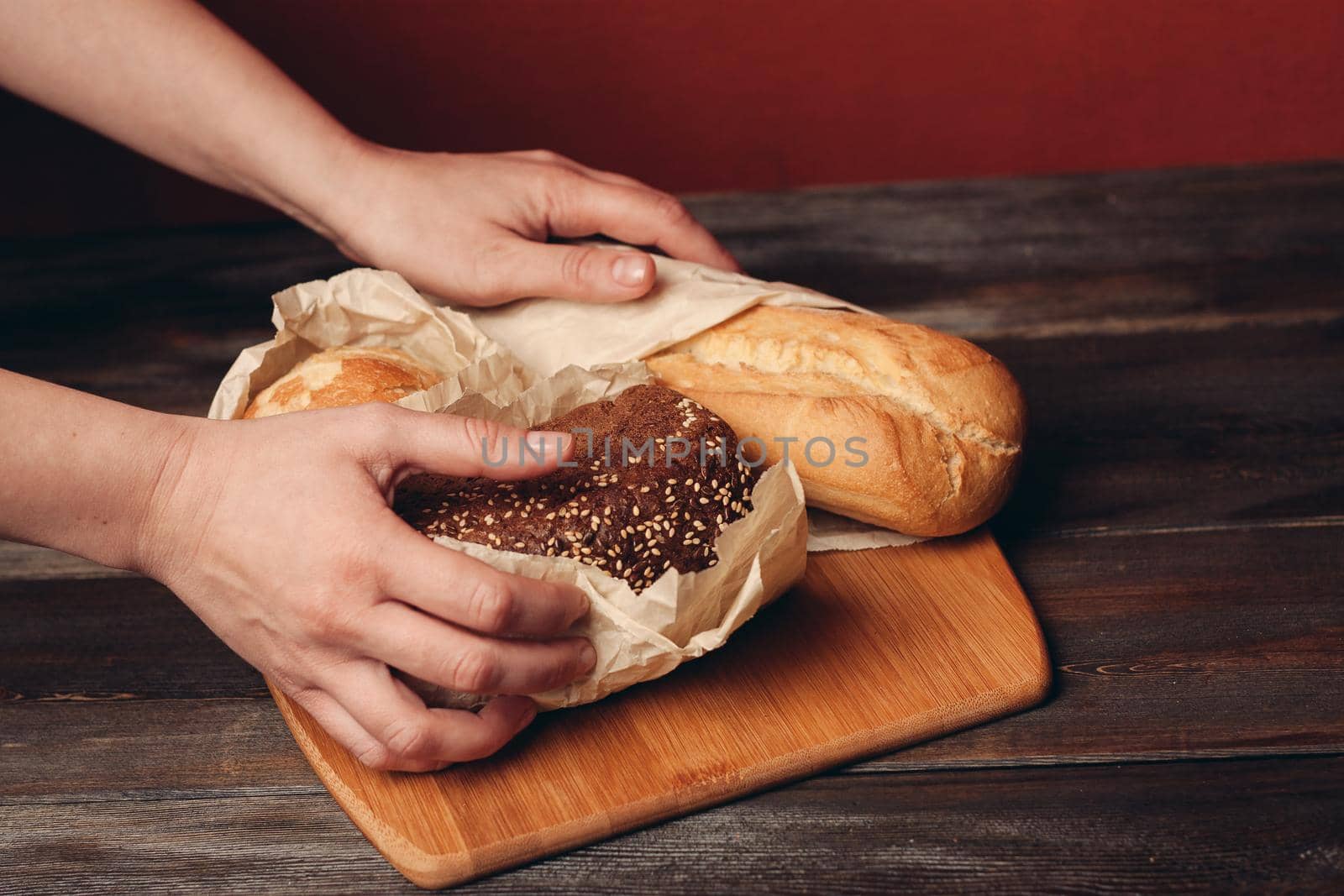 flour products baked loaf of bread on wooden board and red background in the background. High quality photo