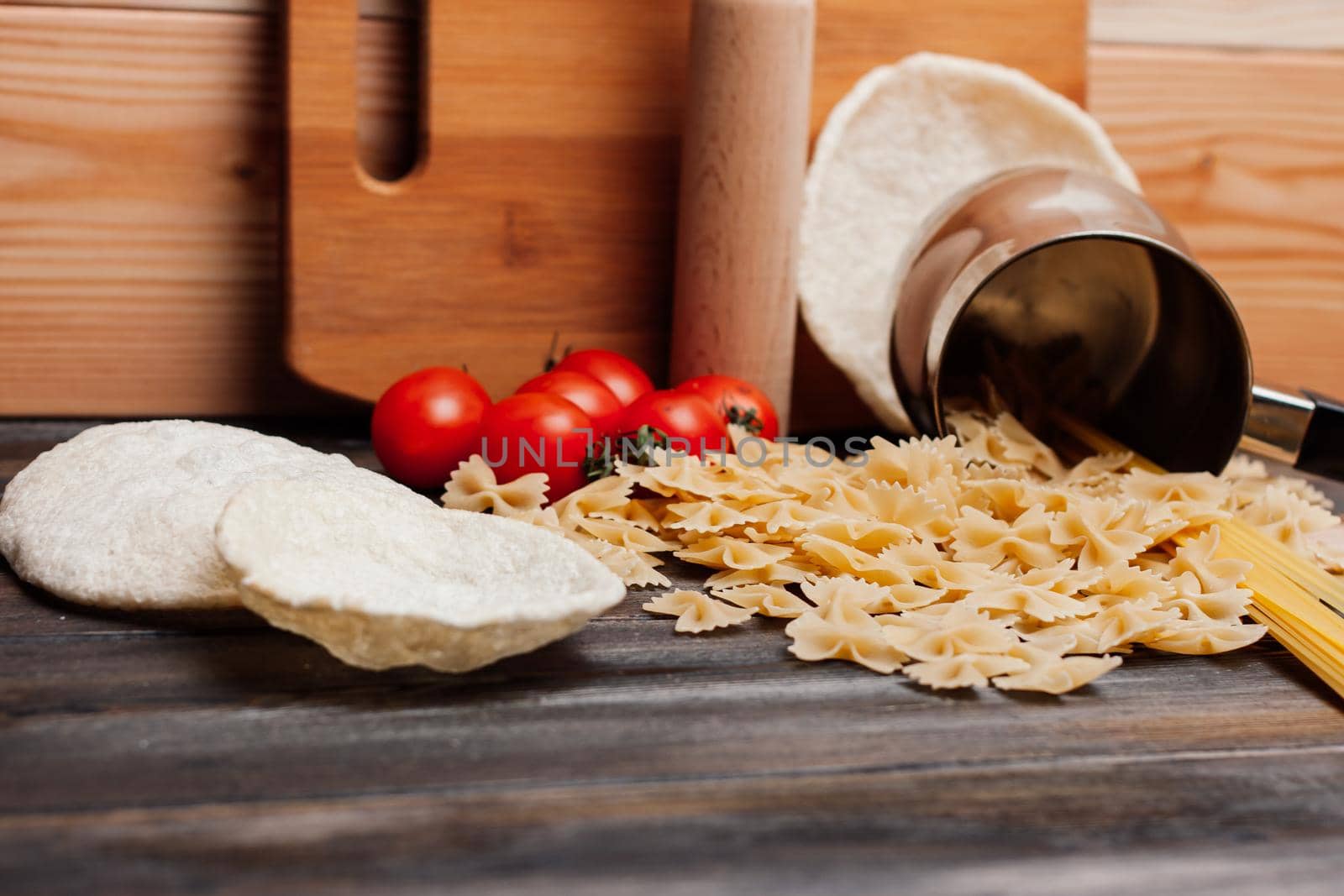 pasta on a wooden table cherry tomatoes kitchenware cooking. High quality photo