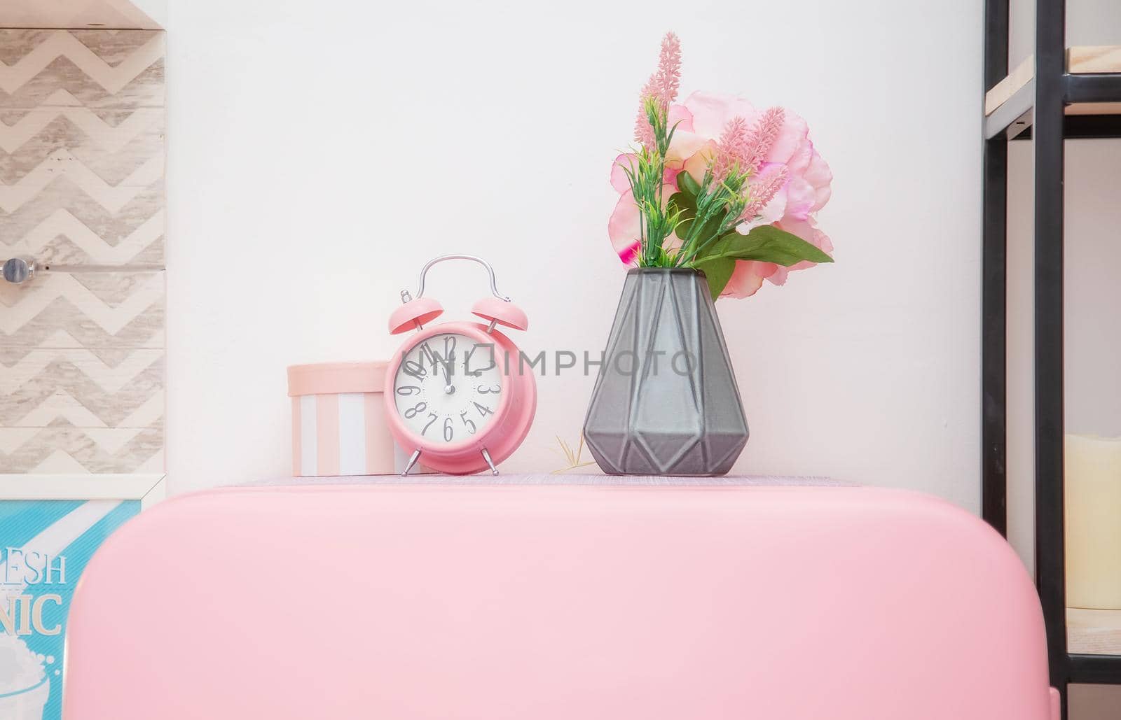 A vase of flowers and a pink alarm clock on the roof of a pink refrigerator by galinasharapova