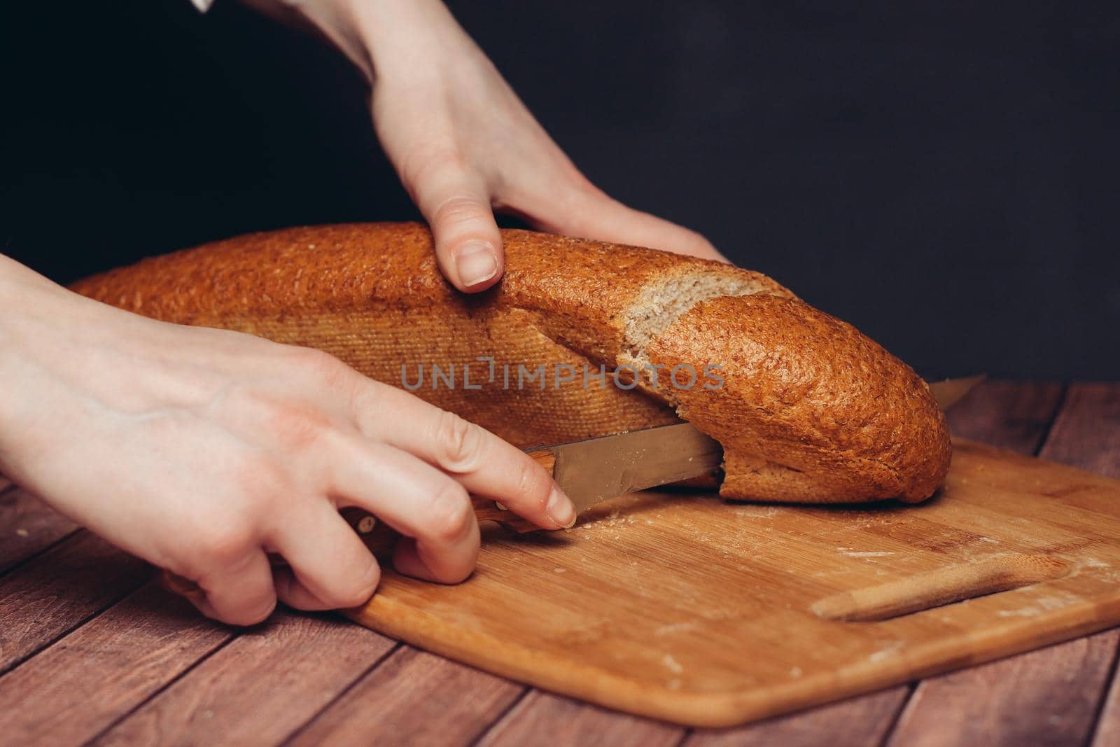 slicing a loaf on a wooden cutting board freshness. High quality photo