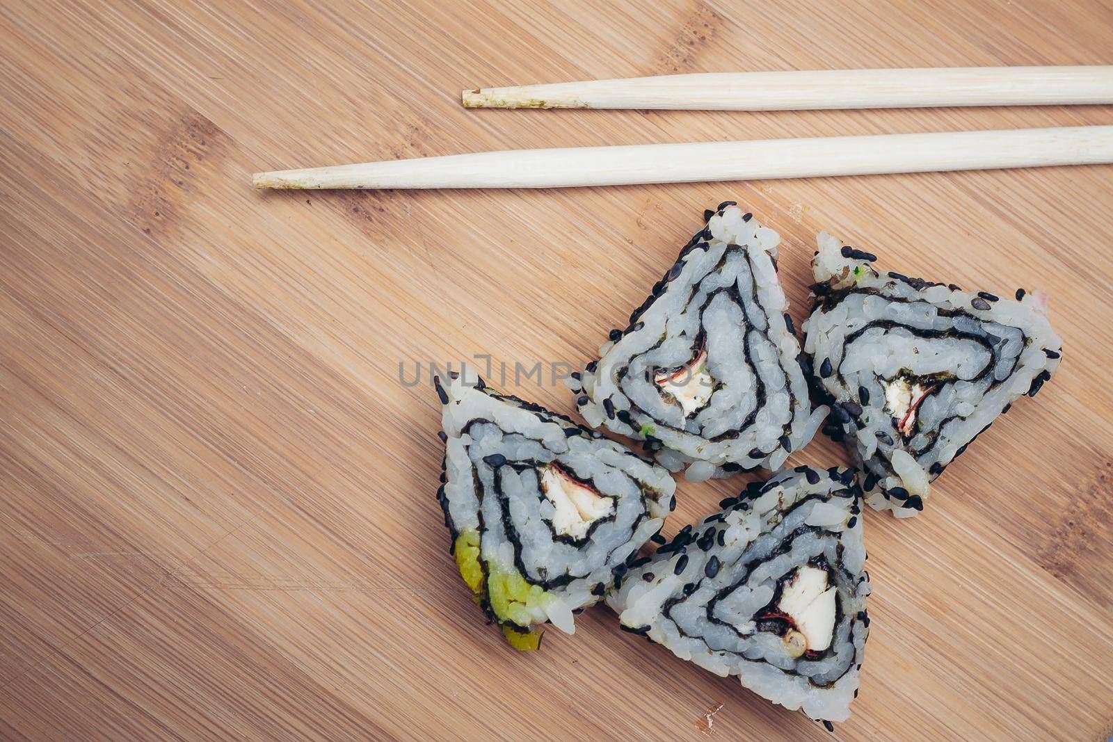 triangular sushi rolls chopsticks wood board japanese cuisine. High quality photo
