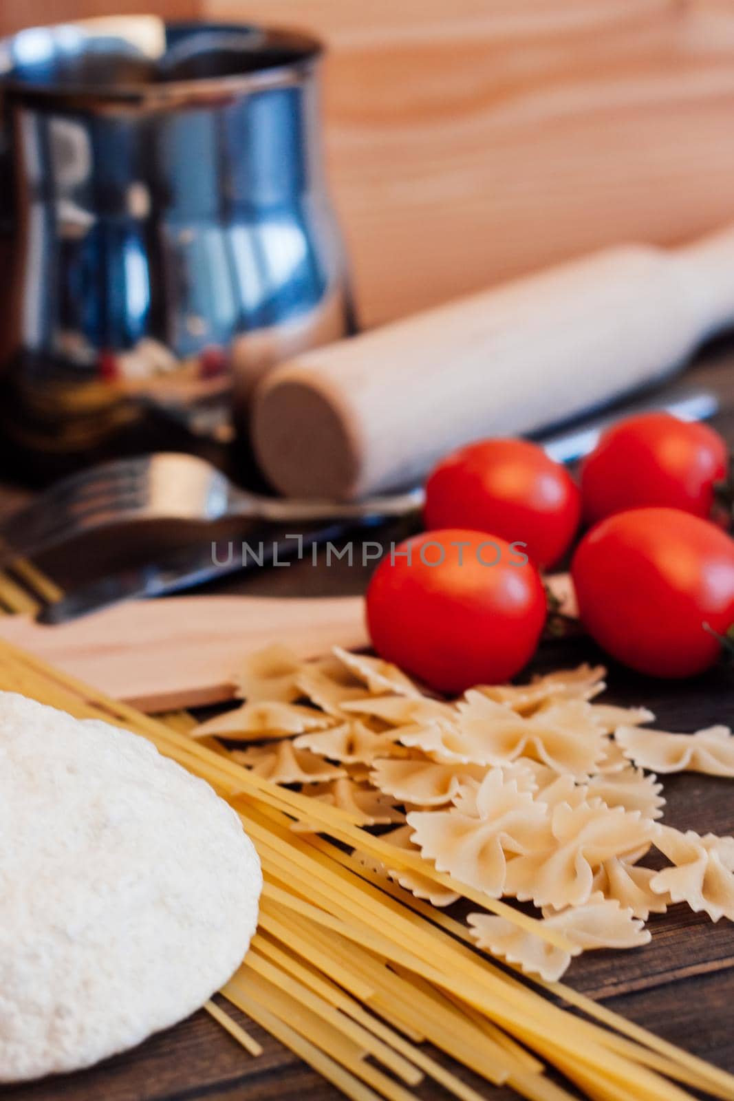 cooking italian pasta by hand kitchen cherry tomatoes ingredients. High quality photo