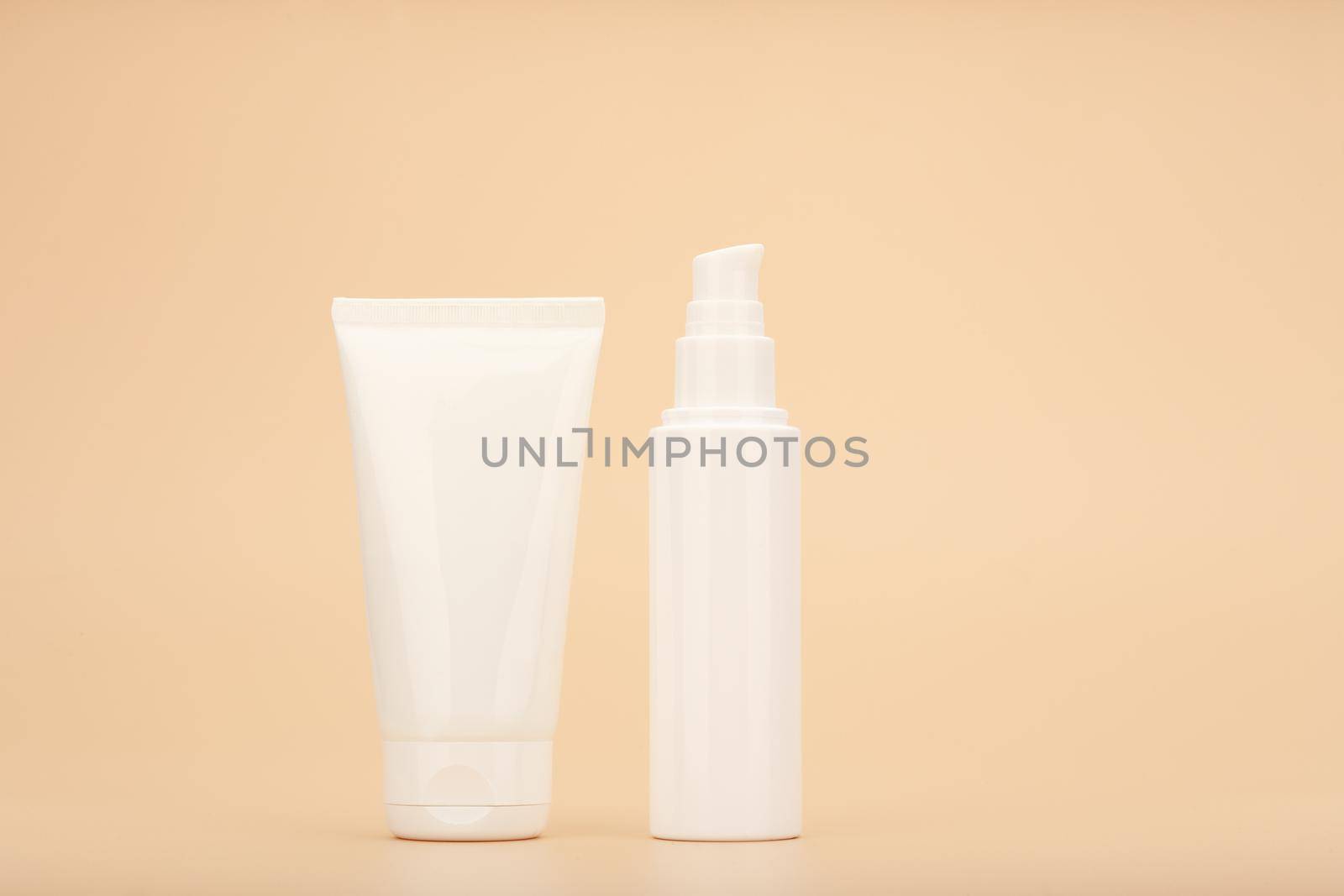 Moisturizing care for face and hands skin. Concept of skin care and beauty. Cream tubes against beige background by Senorina_Irina