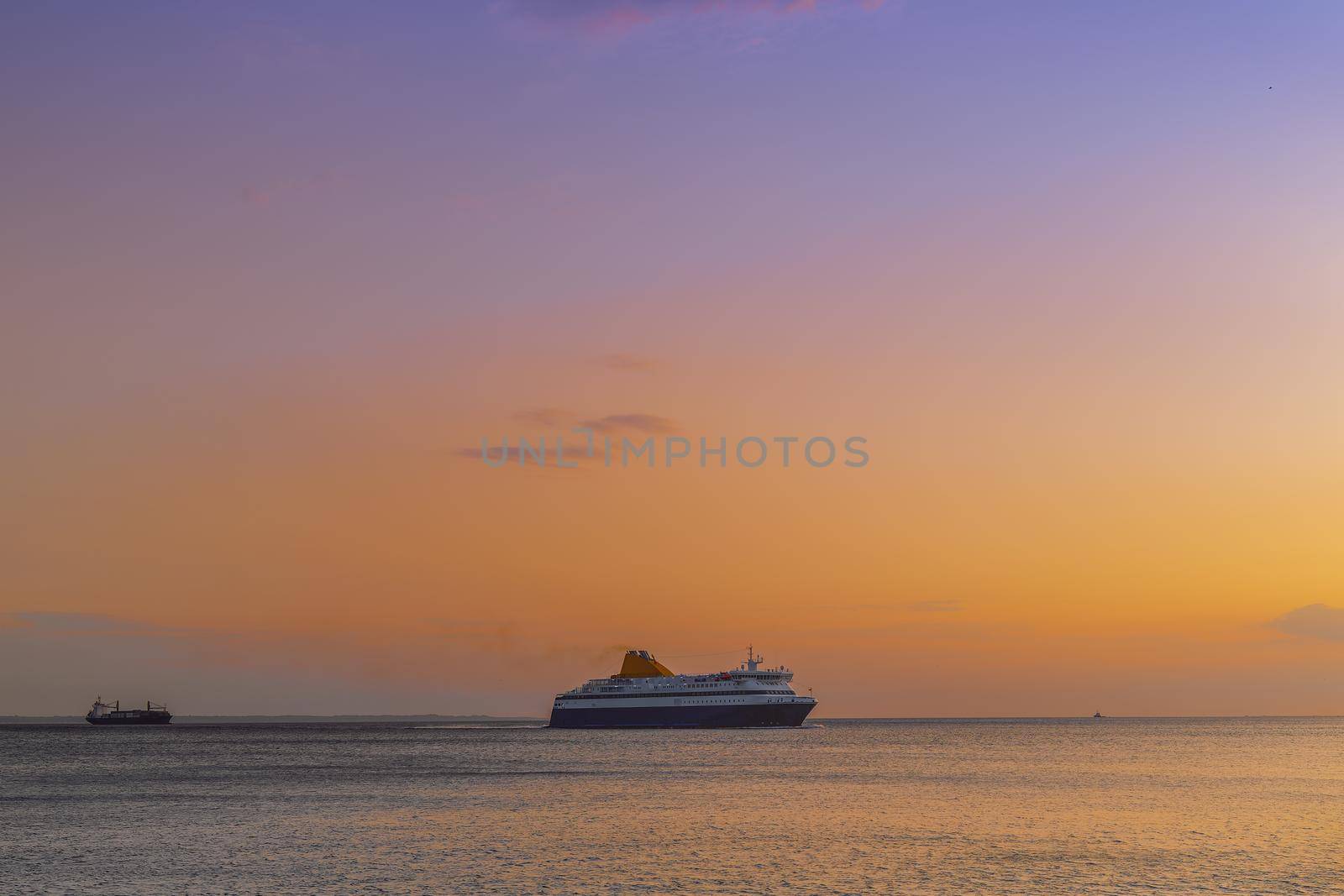 Evening view of commercial boat waiting to enter calm sea harbor.